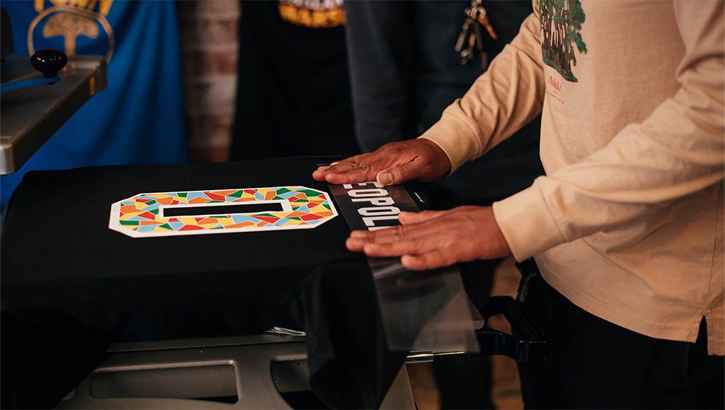 Partial body view of someone heat pressing a jersey.