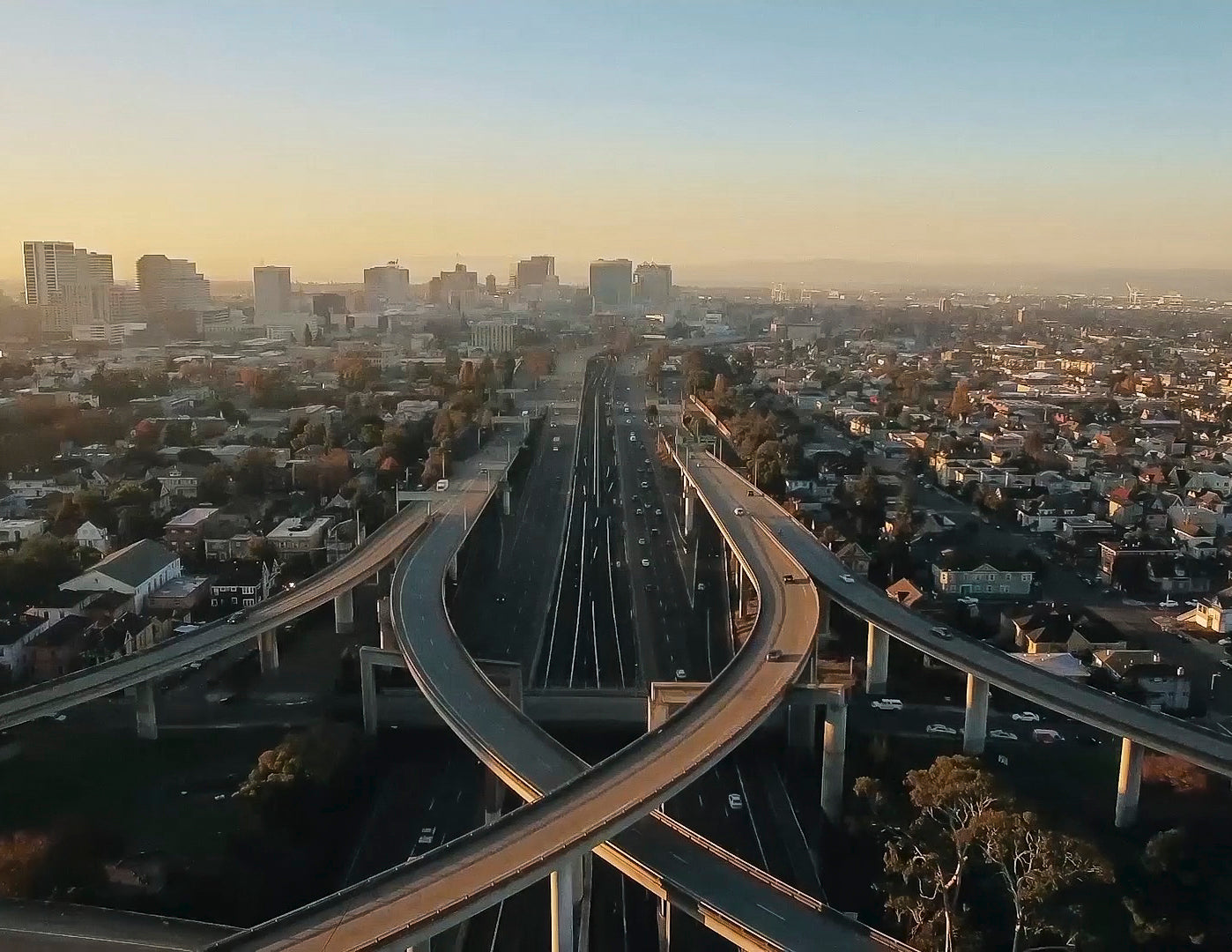 Hazy photo of the freeway overpasses in Oakland, with cityscape in the background.