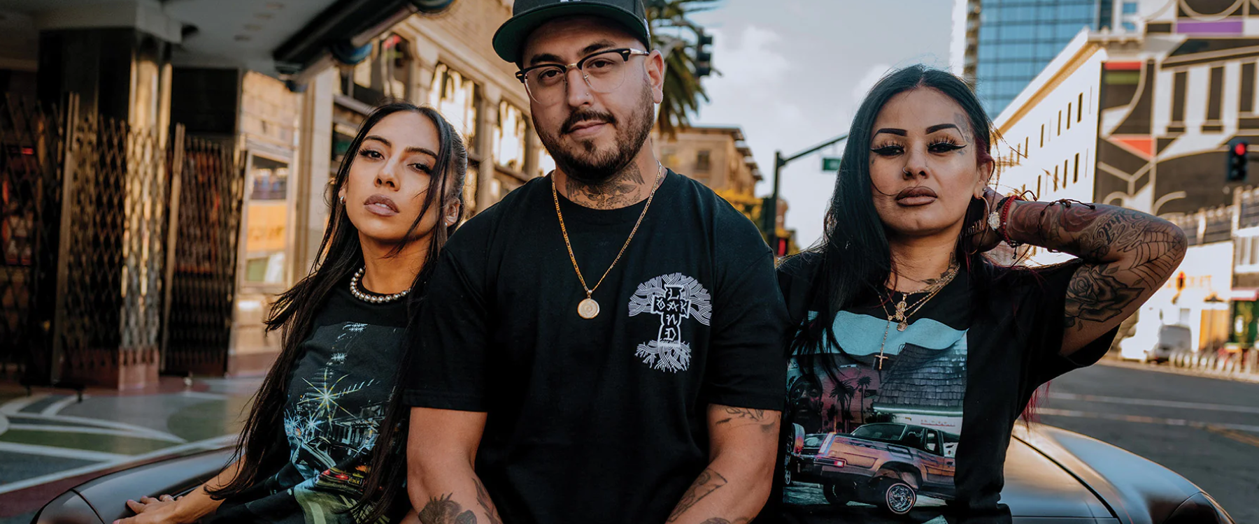 Armando Miranda with two women wearing t-shirts from the Cali Cruise collection at Oaklandish.