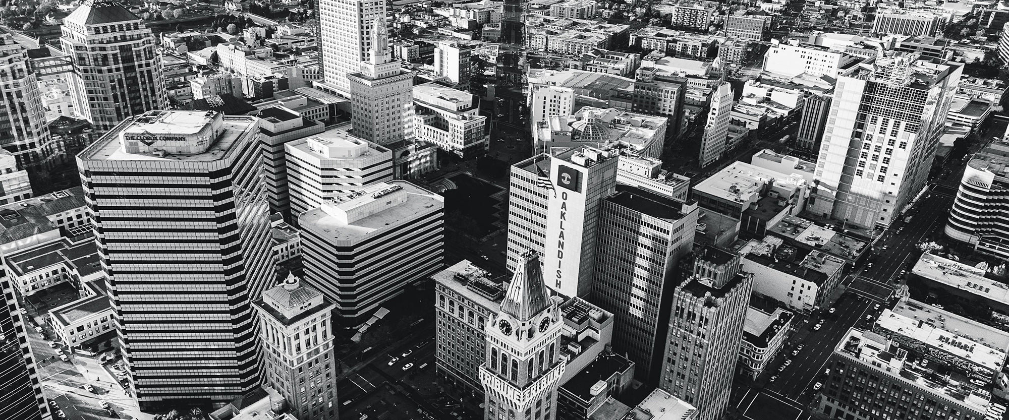 Black and white image of Oakland skyline with a building with Photoshopped Oaklandish branding.