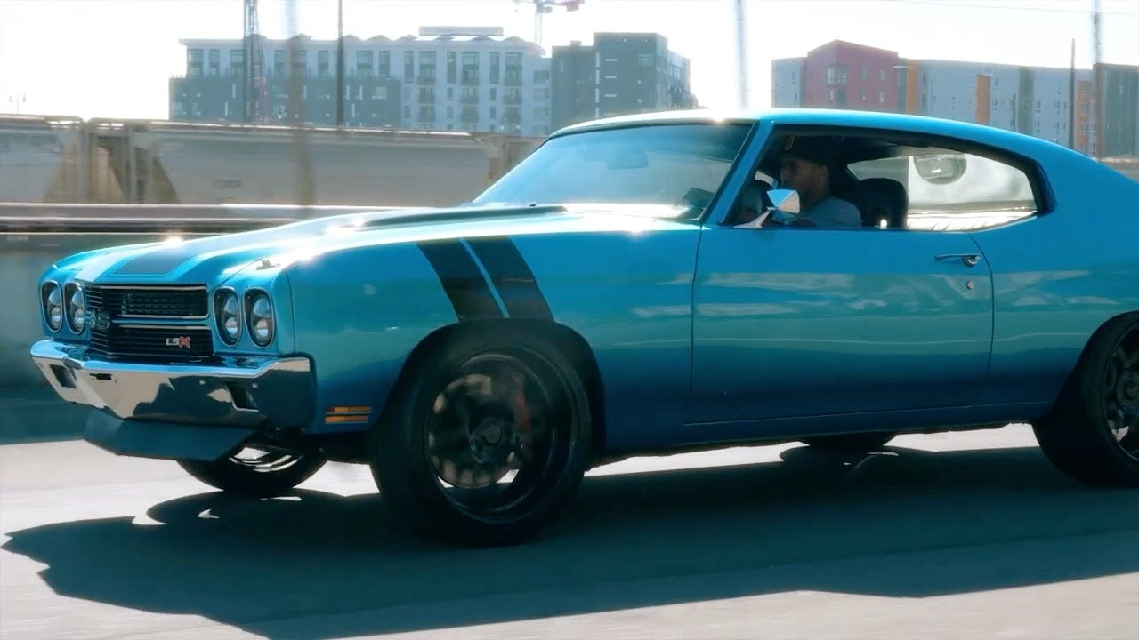 A really cool looking blue car on the road.