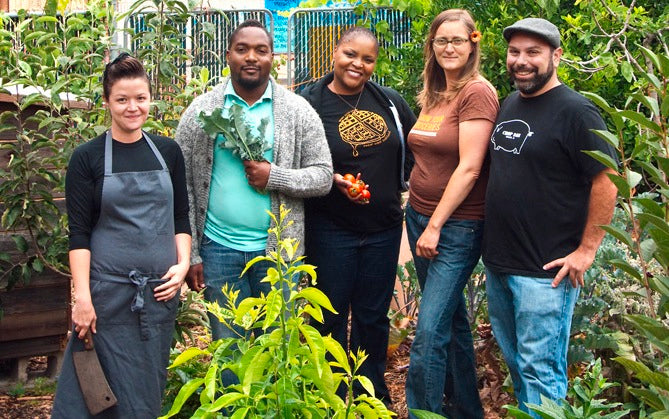 Group photo of people featured, in a  garden.