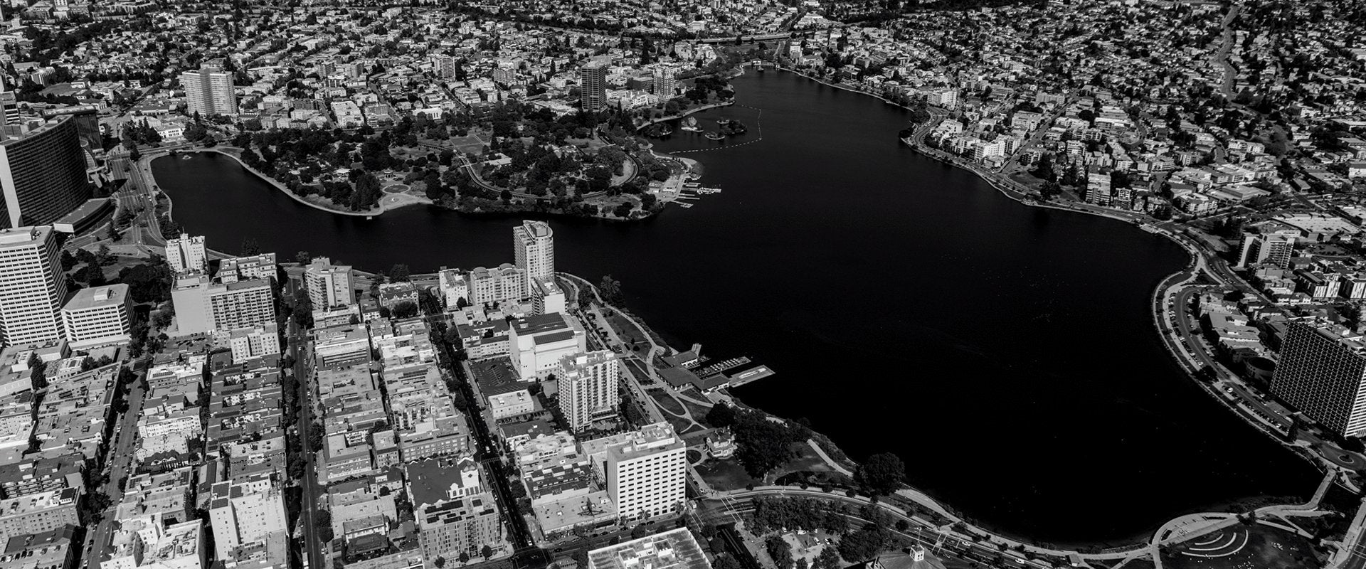 A black and white aerial view of Oakland with Lake Merritt as the focus.
