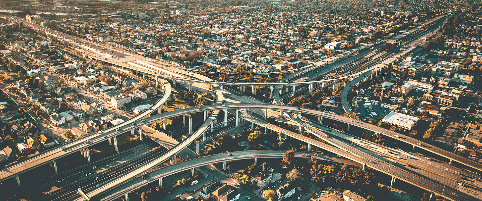 Aerial view from helicopter of the Macarthur maze freeway system, with elevated ramps and streets and houses.