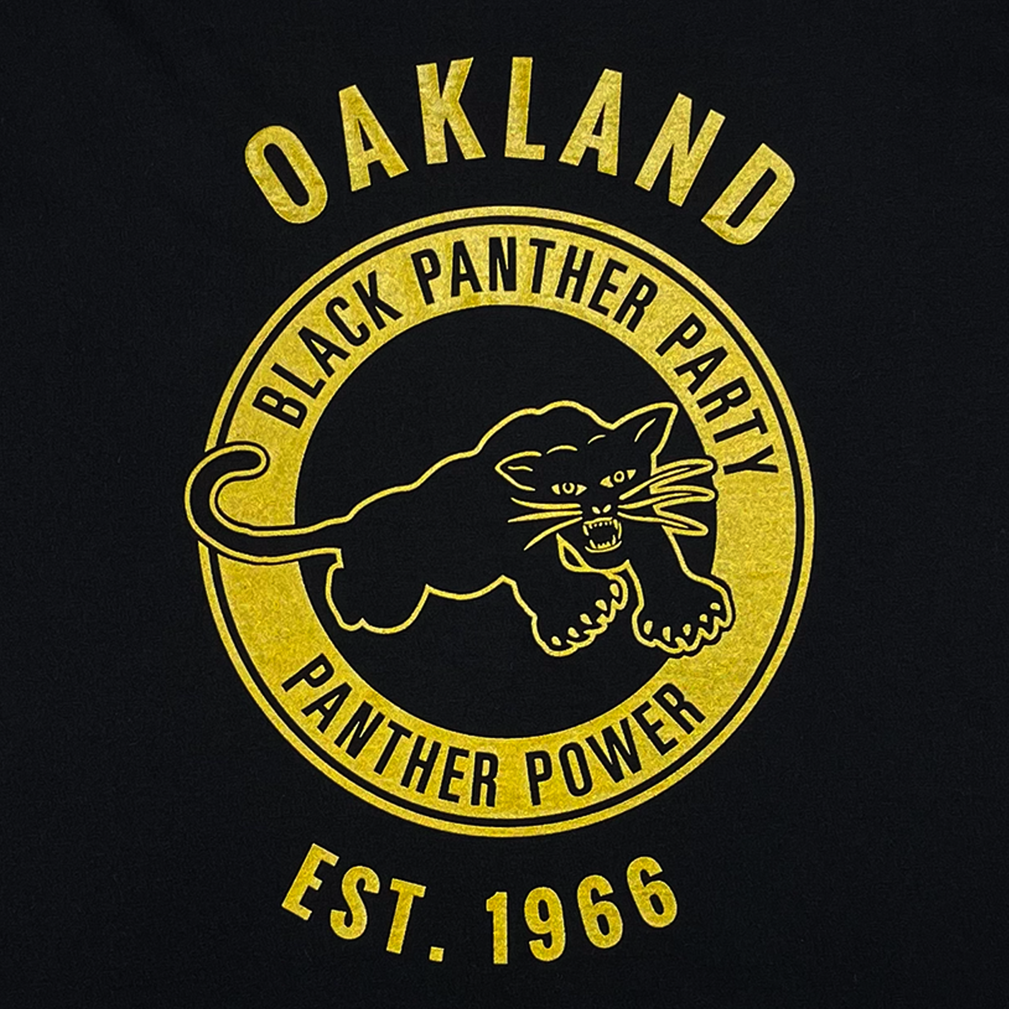 The Oaklandish Black Panther Power Tee features a yellow and black circular emblem reading “Oakland Black Panther Party Panther Power Est. 1966” with a fierce panther at the center, set on a black background.