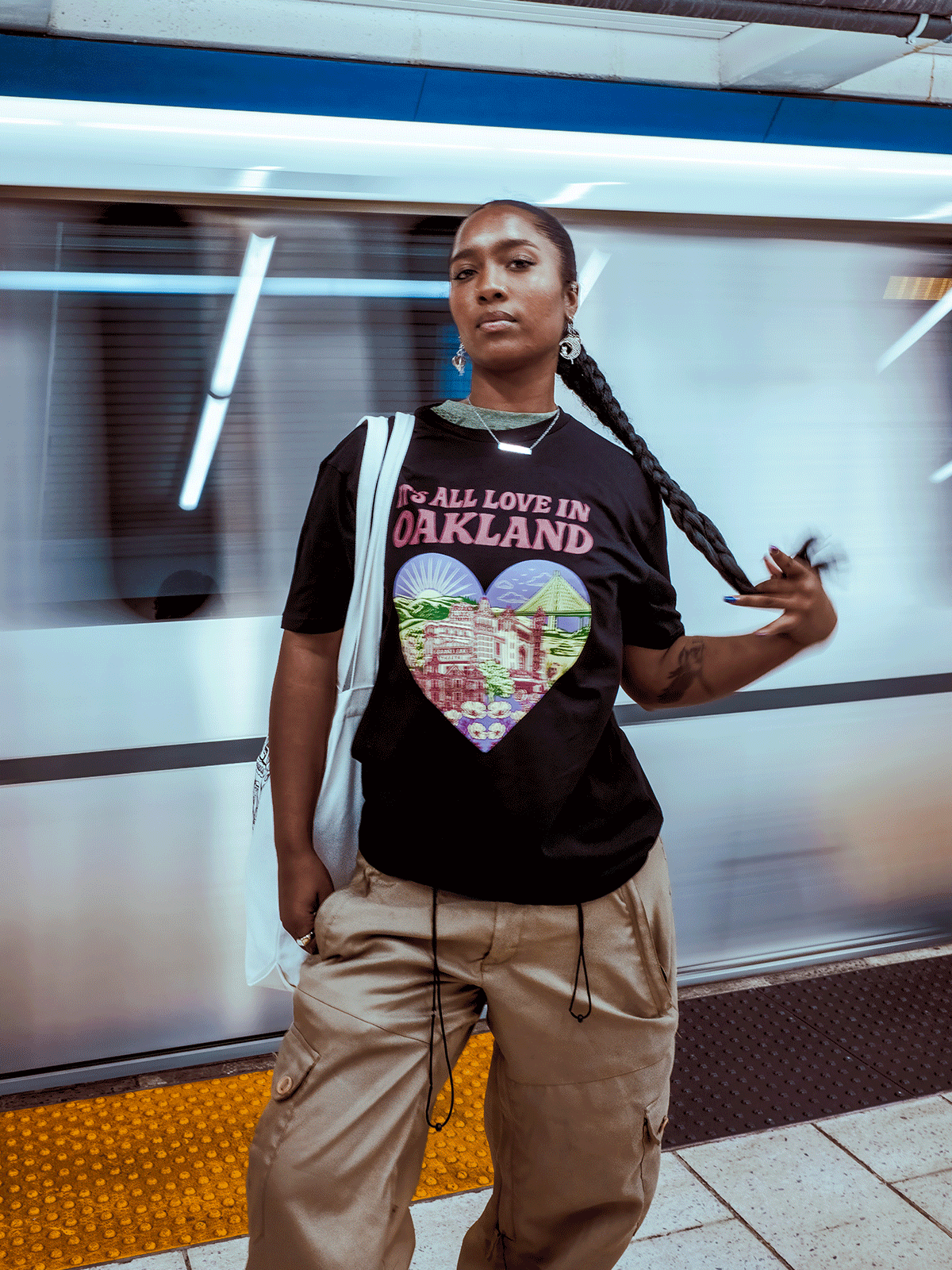 girl standing on BART platform wearing black Oaklandish t-shirt