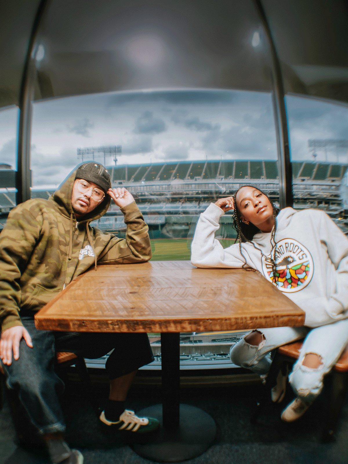 male and female at Oakland Coliseum wearing Oakland Roots hoodies