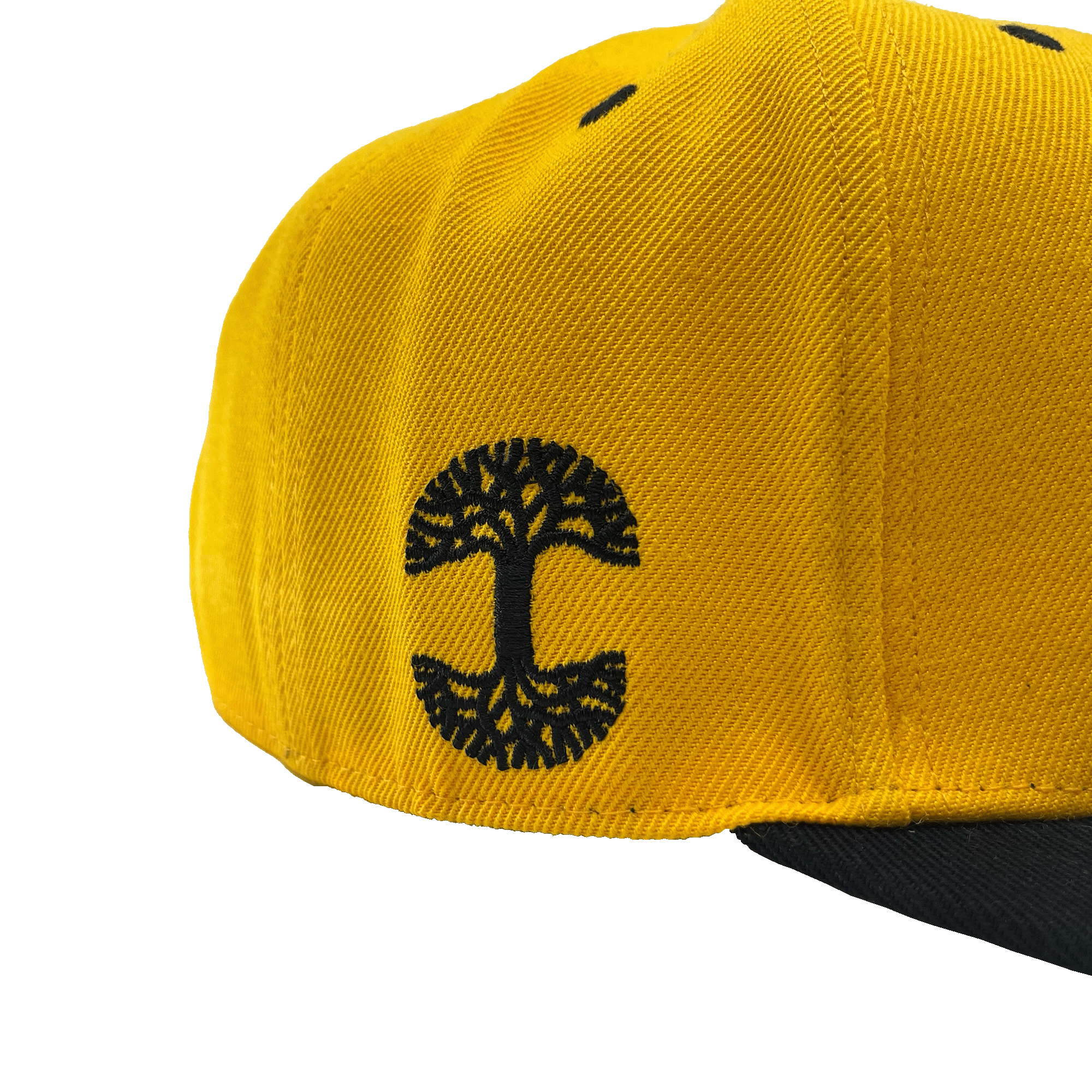 Side view of a yellow hat and black embroidered Oaklandish tree logo on the wearer's right side. 