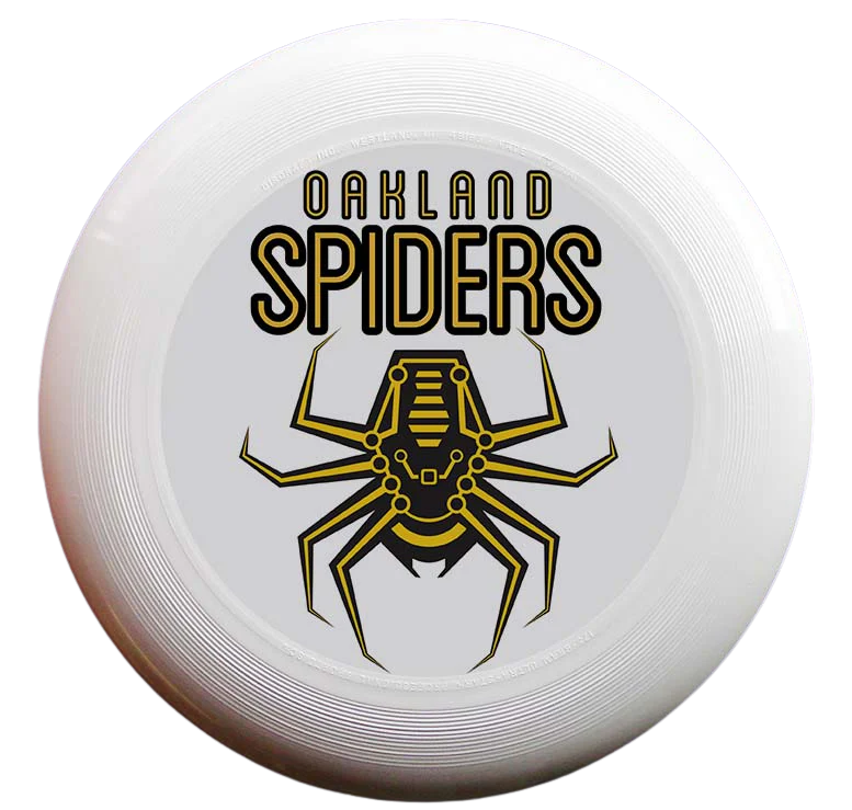 The Oakland Spiders Disc by Supported Brands is a white Ultimate Frisbee featuring the Oakland Spiders logo prominently in the center. The logo showcases a stylized spider with yellow and black details, with "Oakland Spiders" written above in bold, black and yellow font. This disc is perfect for youth development thanks to its solid white background.