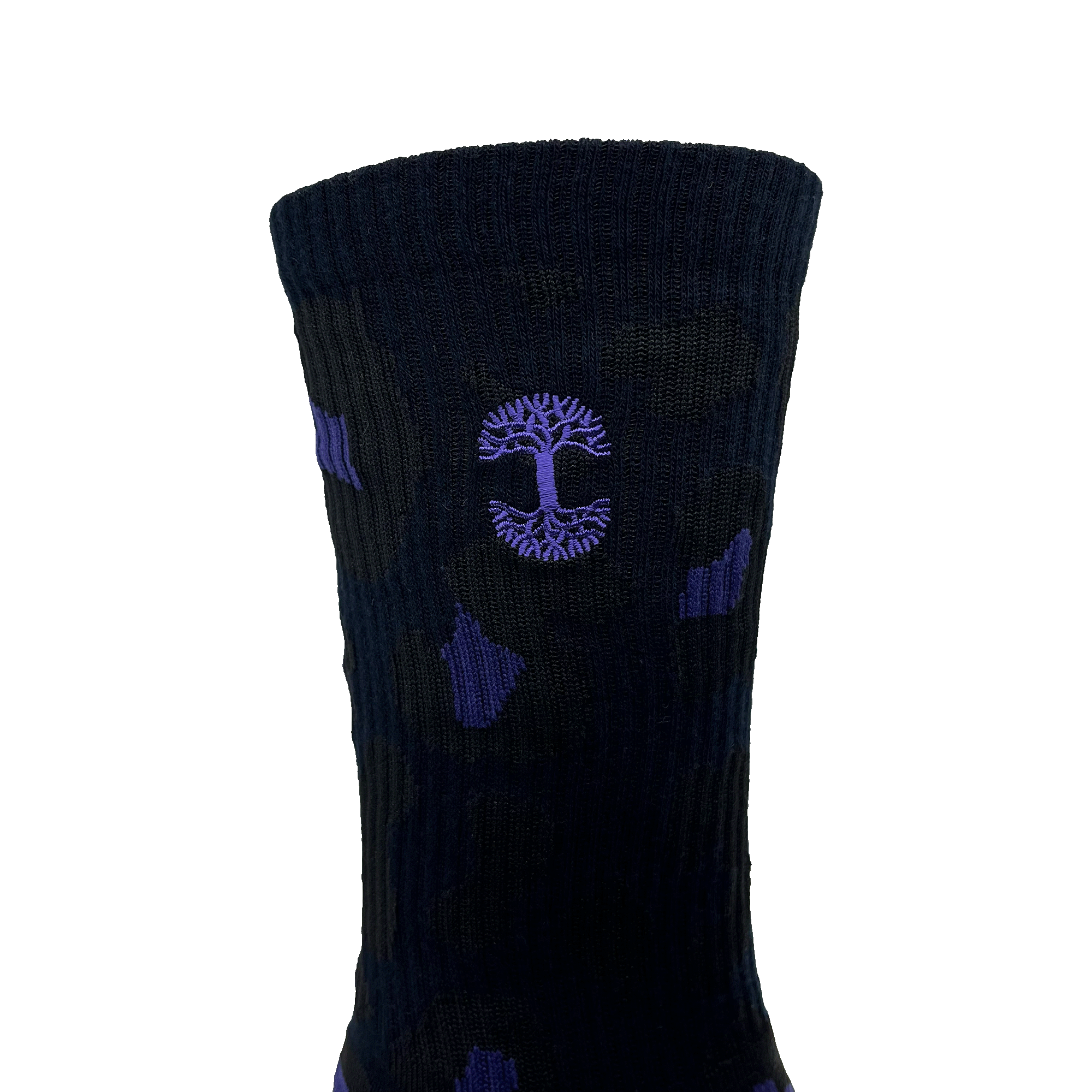 The Panther Sock by Oaklandish is displayed against a solid green background, showcasing its dark color with the Oaklandish logo prominently featured in the center. This one-size-fits-most crew sock has a ribbed texture, with the emblem outlined in purple within a circular design and slight purple accents scattered throughout.