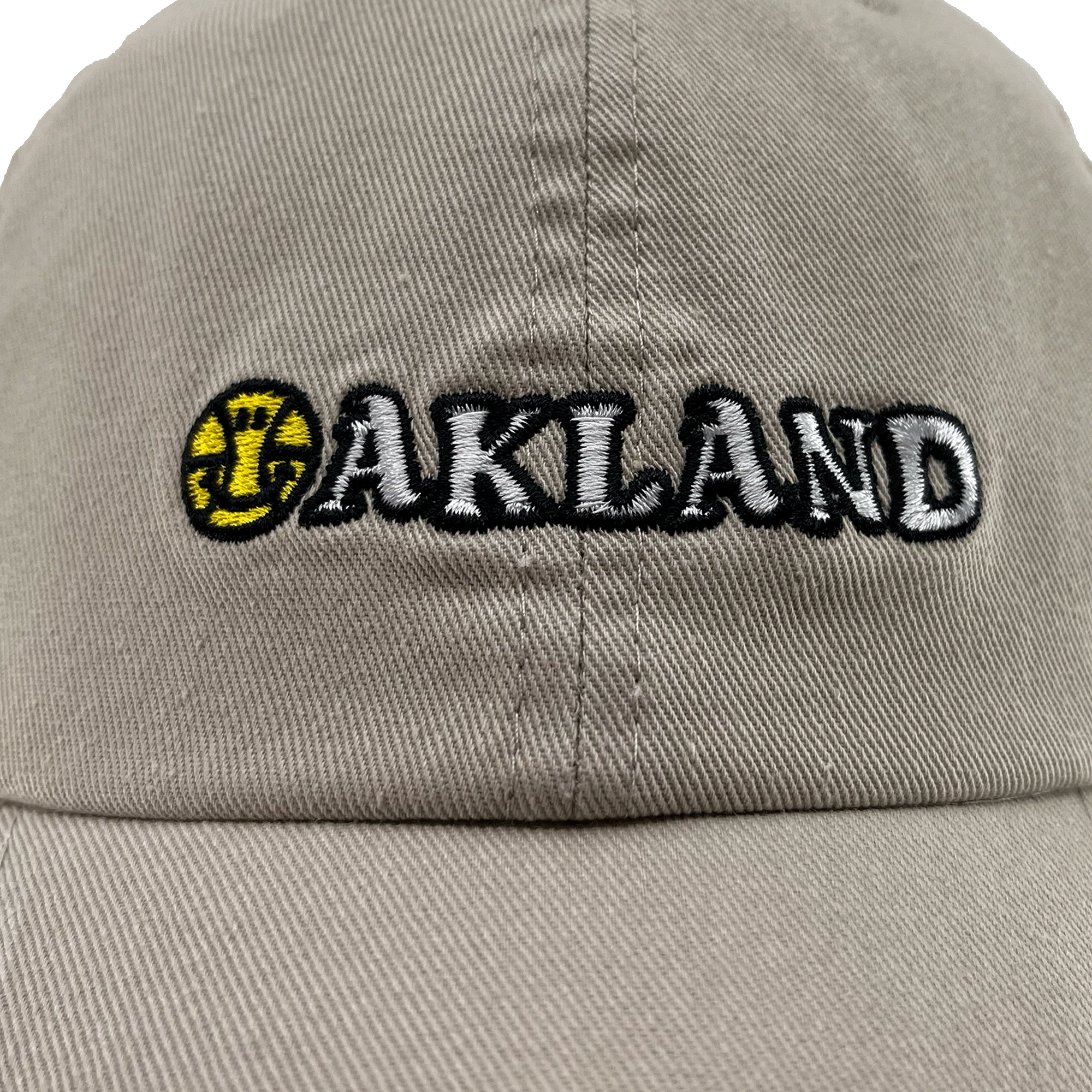 Close-up front view of khaki Oakland Dad Hat, with embroidered wordmark design by Dustin O. Canalin (DOC).