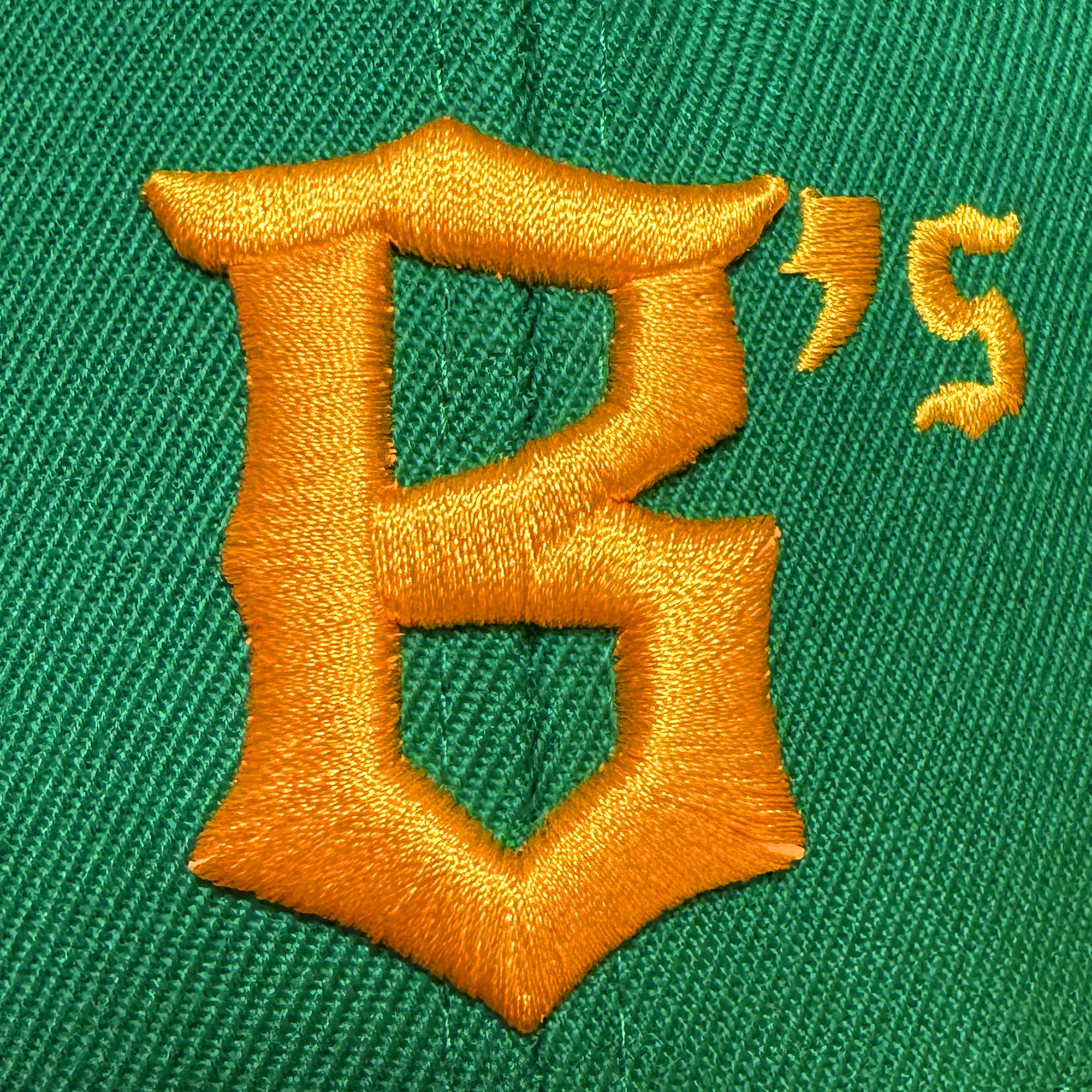 Close-up of the Oakland Ballers Snapback, a green hat featuring a bold, gold embroidered “B’s” above the seam—the thick, shiny stitching reflects the vibrant spirit of the Oakland Ballers brand.
