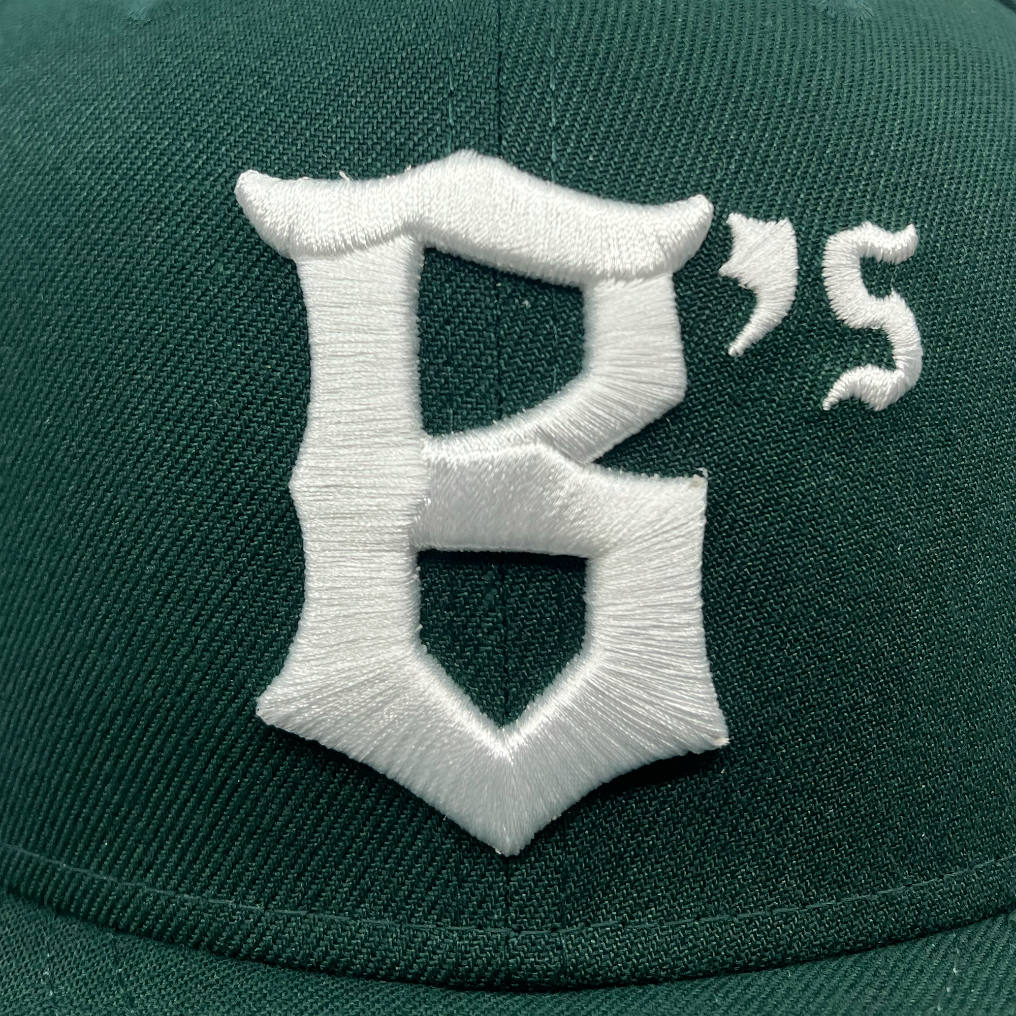 Detail front of Oakland Ballers B's logo in white on New Era 59FIFTY Dark Green Oakland Ballers fitted.