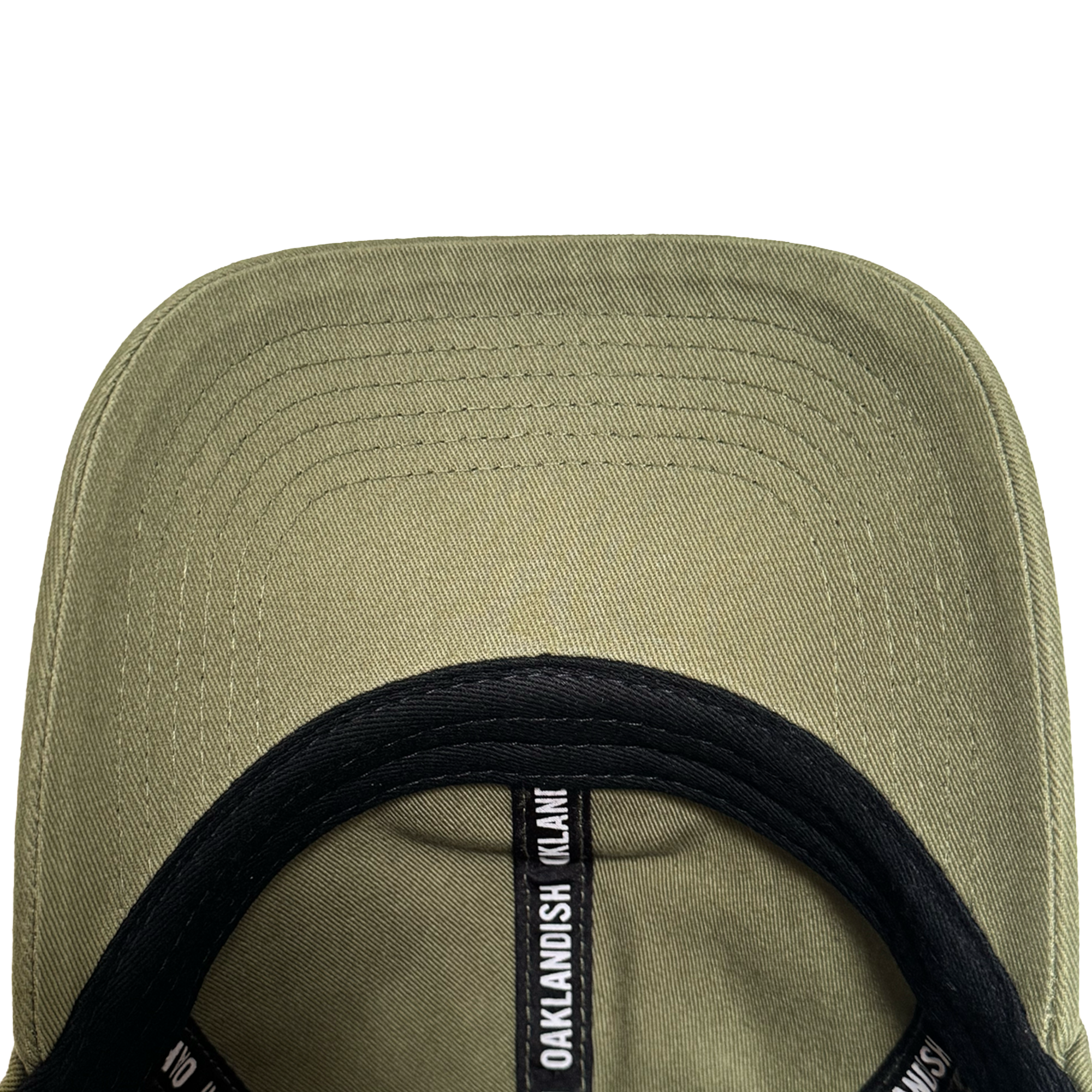 Close-up underside view of the olive green AC Transit Dad Hat brim with parallel stitching. A black sweatband features repeating white "Oaklandish" logo labels, celebrating East Bay style by Oaklandish.