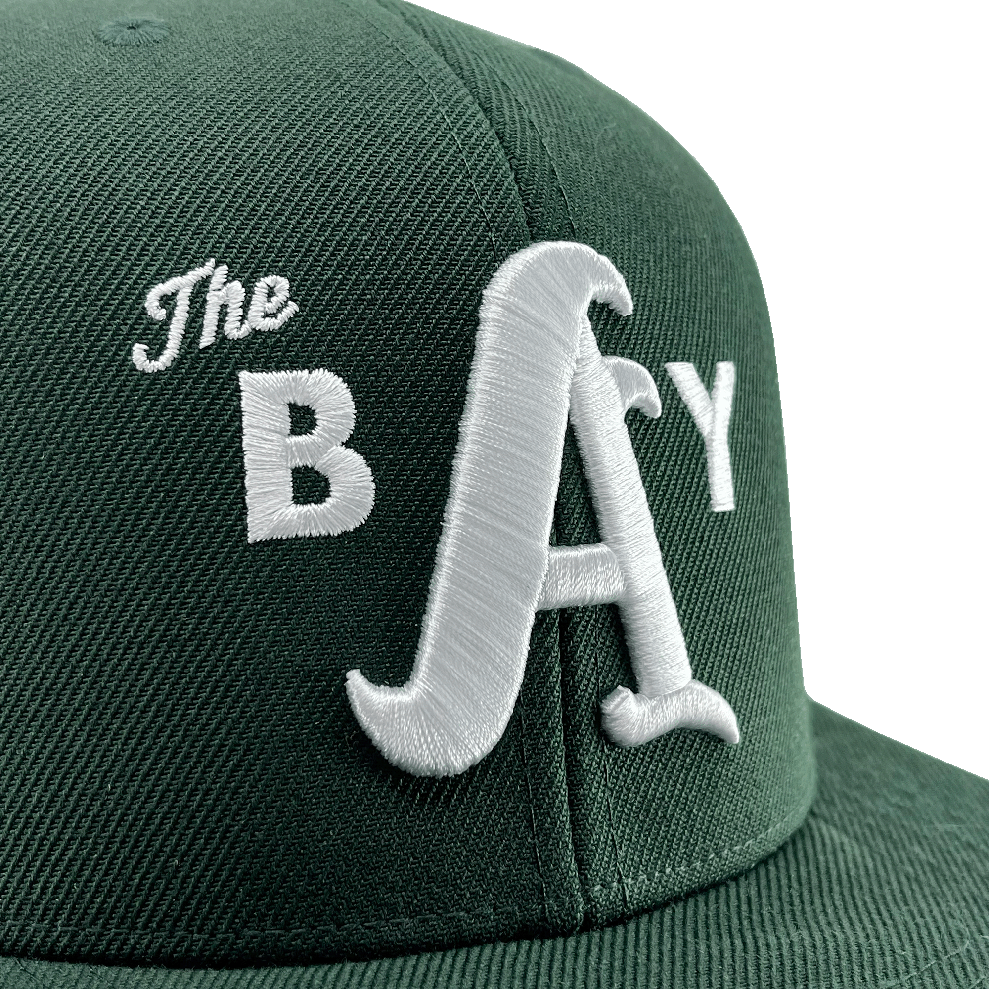 Close-up angled side view of a forest green hat with a green bill and white embroidery of the Bay logo on the front crown.