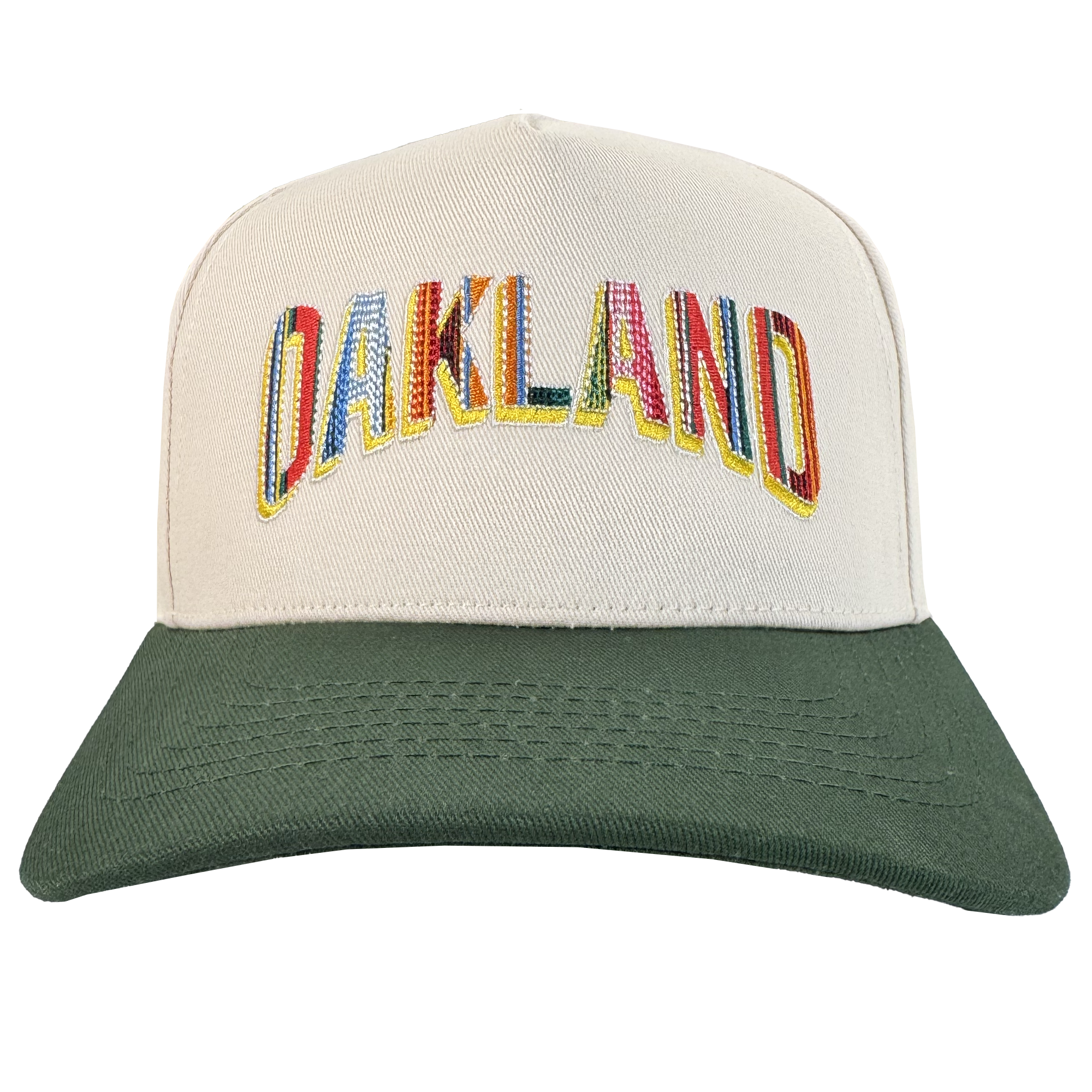 The Oakland Ballers Oakland Beisbol 5 Panel Cap features a beige body, dark green brim, and "OAKLAND" in large, patterned letters outlined in yellow—celebrating Oakland baseball's vibrant spirit. Photo background is plain white.