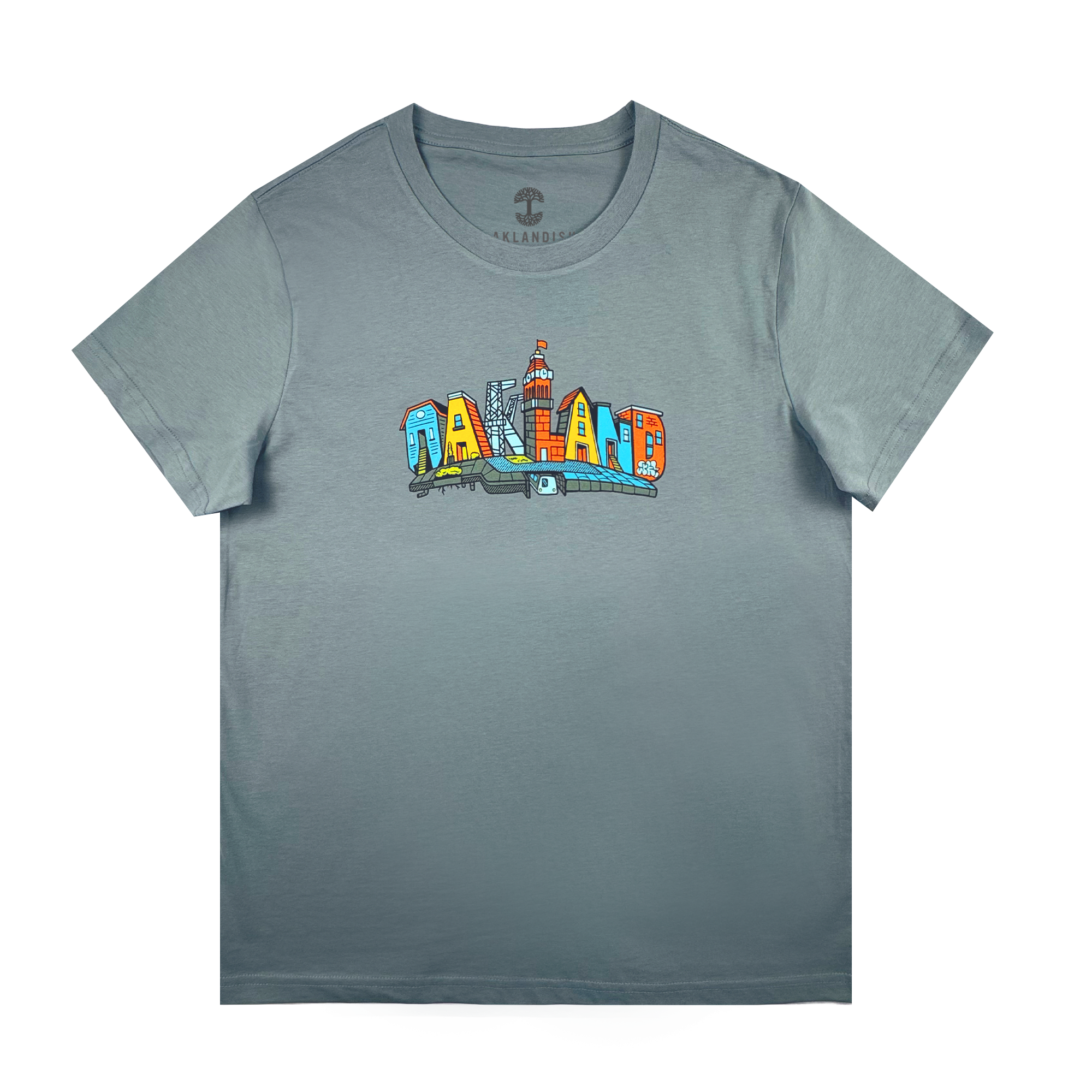 The Oaklandish Women's Blockletters Tee is a gray cotton shirt with "OAKLAND" in bold, colorful cartoon-style letters featuring city elements and skyline details, all above a subtle shadow graphic.