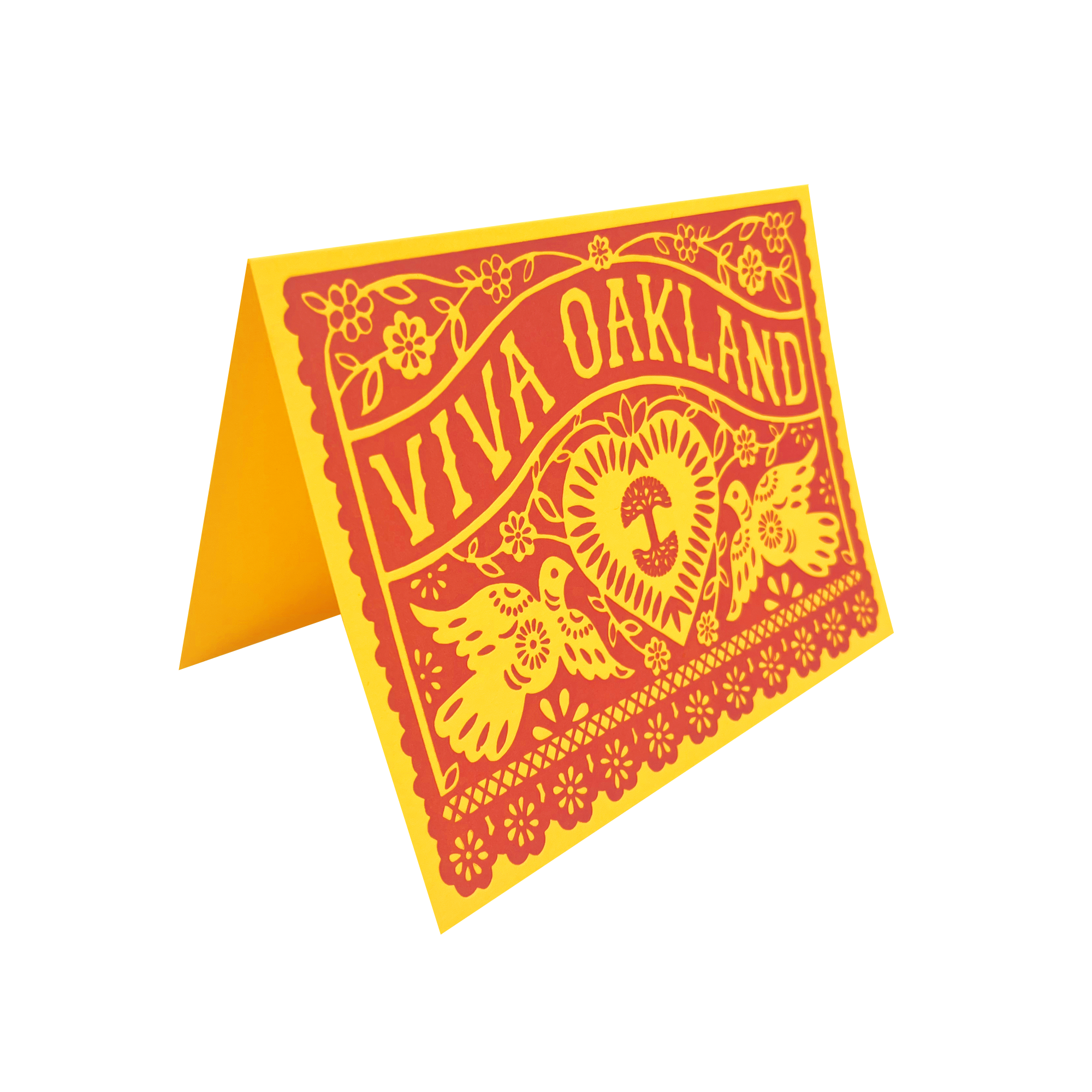 The Viva Oakland Card by Never Elsewhere is a yellow, tent-fold greeting card adorned with an intricate red design of flowers, leaves, and two birds encompassing a heart pierced by an arrow and cross. The bold text "Viva Oakland" crowns the design, reminiscent of traditional papel picado. This beautiful artwork is printed on recycled brown kraft paper.