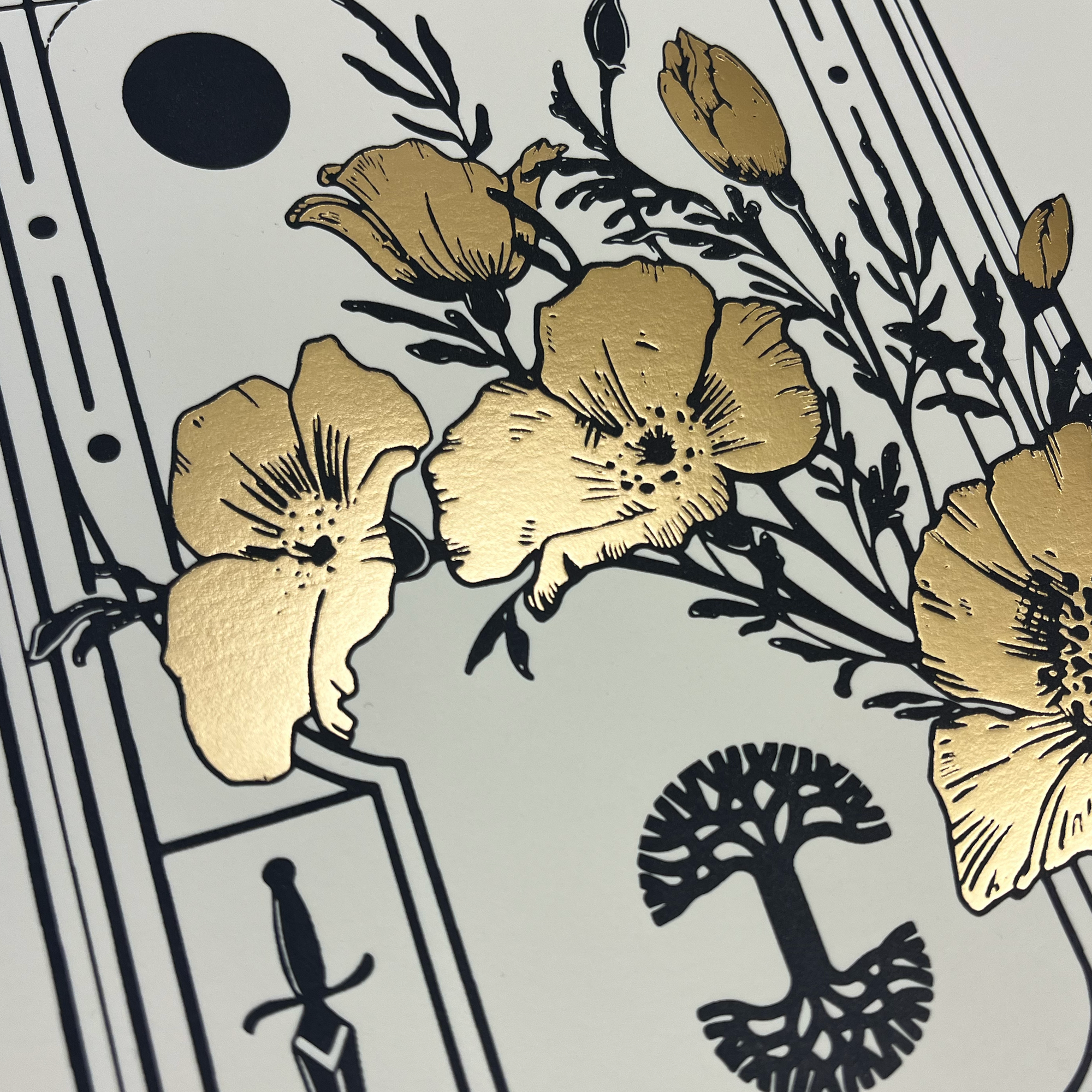 A close-up of the Never Elsewhere "Blossom Print" reveals a cluster of golden flowers with black stems and leaves. The white background features black geometric patterns, a small black circle near the top, and a stylized black tree positioned towards the bottom right.
