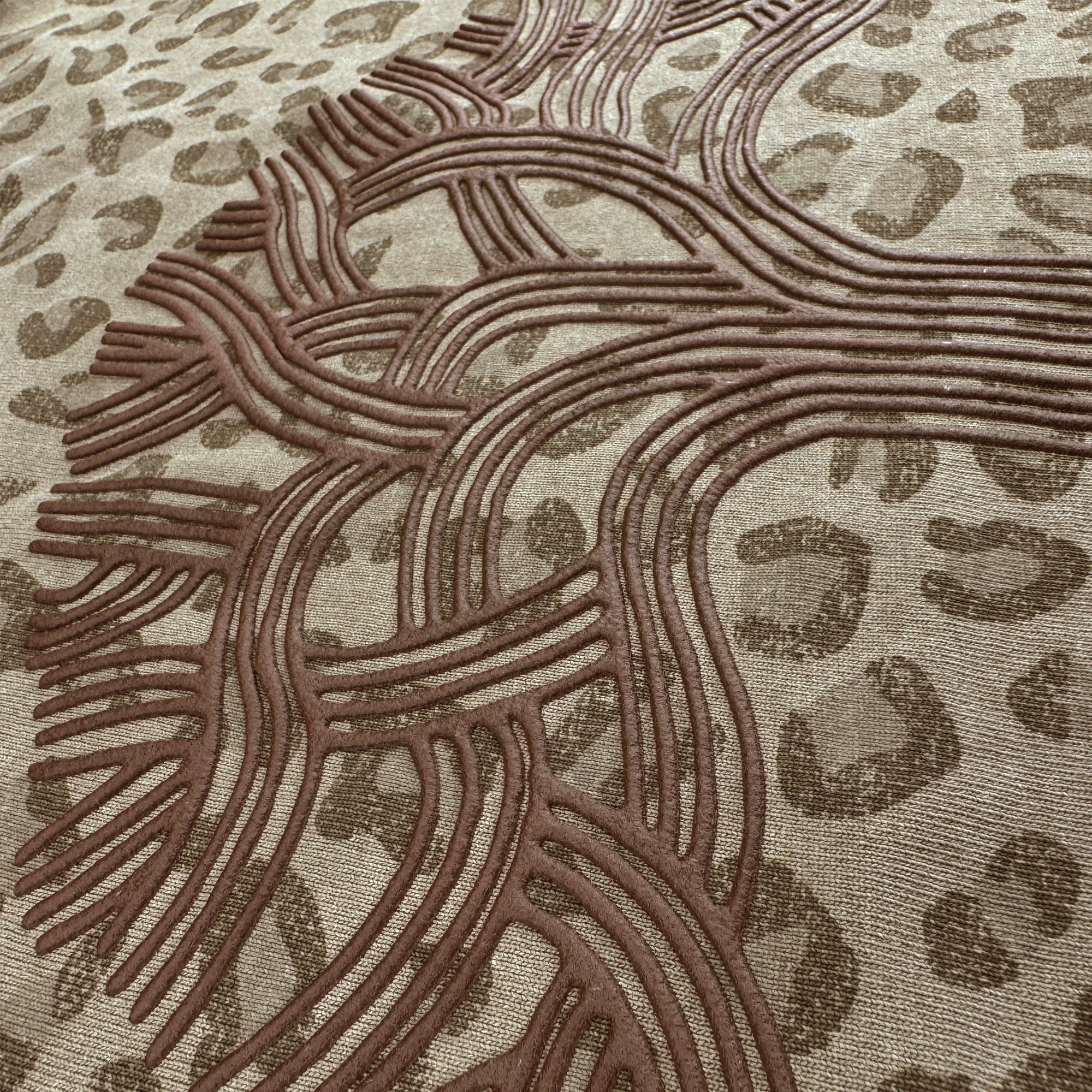 The Oaklandish Classic Logo Tee by Oaklandish features heavyweight cotton with a raised, brown tree pattern over a beige and brown leopard print background, creating a unique, tactile look perfect for an oversized fit.