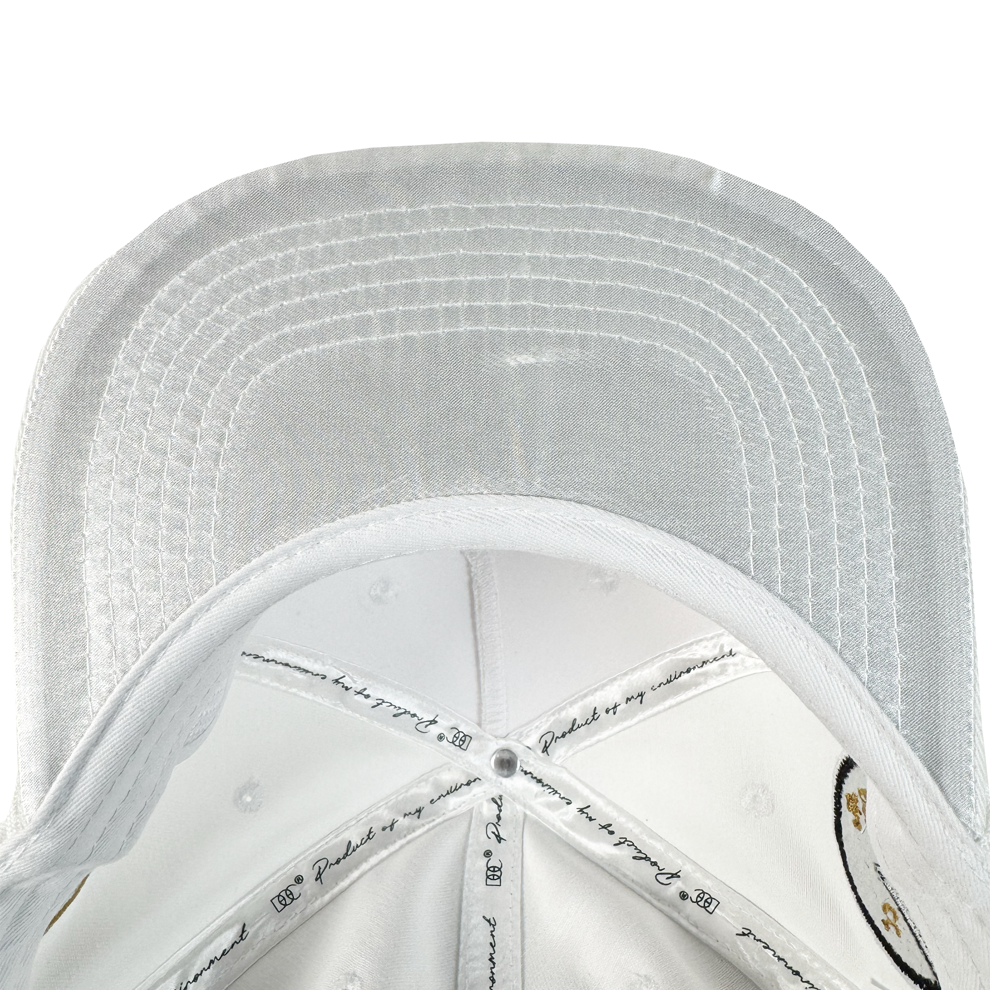 A close-up of the underside of the white Bay Area 5 Panel by DOC from Oaklandish, featuring detailed stitching on the brim and panels, printed text, illustrations, and ventilation holes throughout.