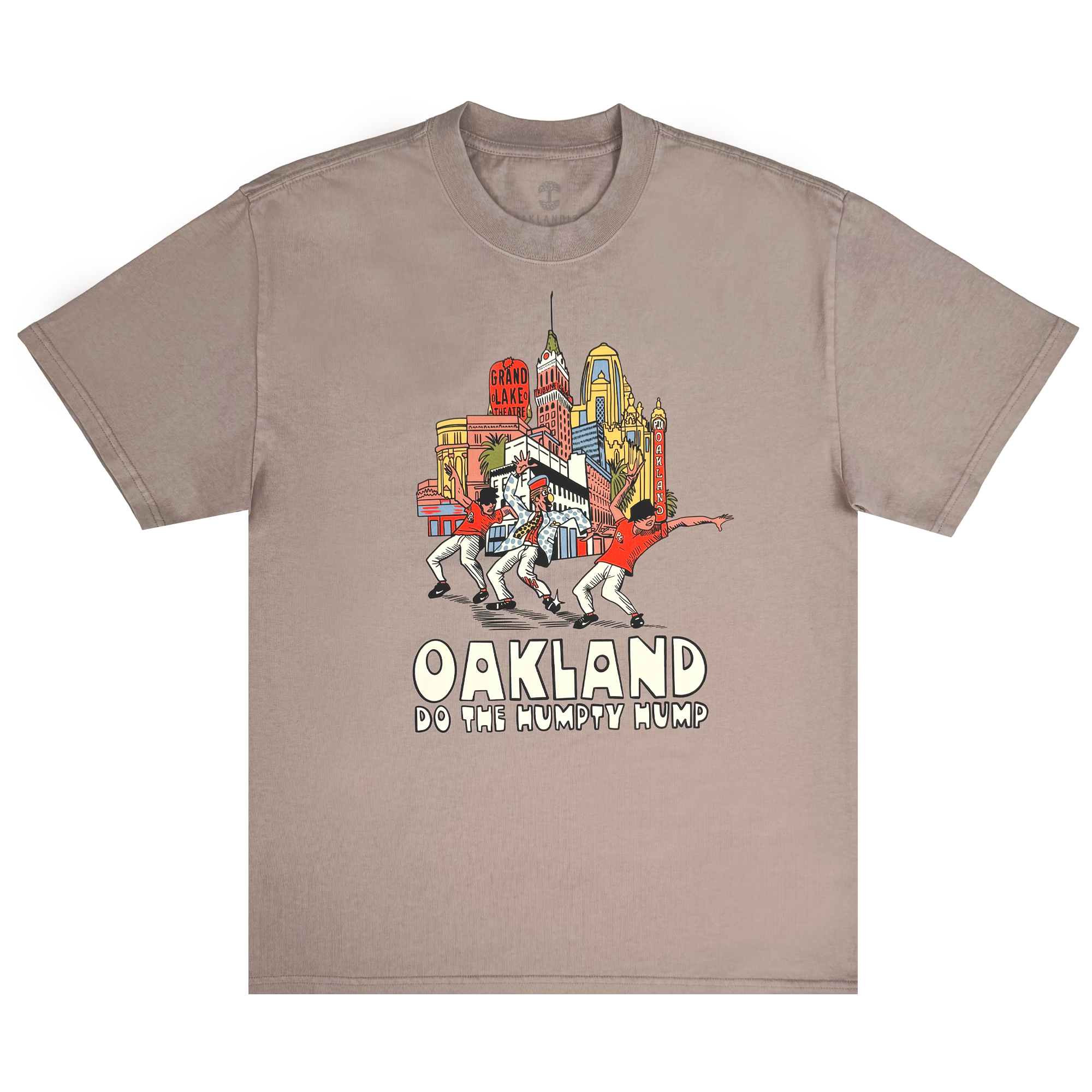 The Do the Humpty Hump Heavy Tee by Oaklandish showcases a taupe shirt with iconic Oakland landmarks and palm trees. It features four dancers performing the "Humpty Hump" as a tribute to Digital Underground, with "OAKLAND DO THE HUMPTY HUMP" in stylized font.