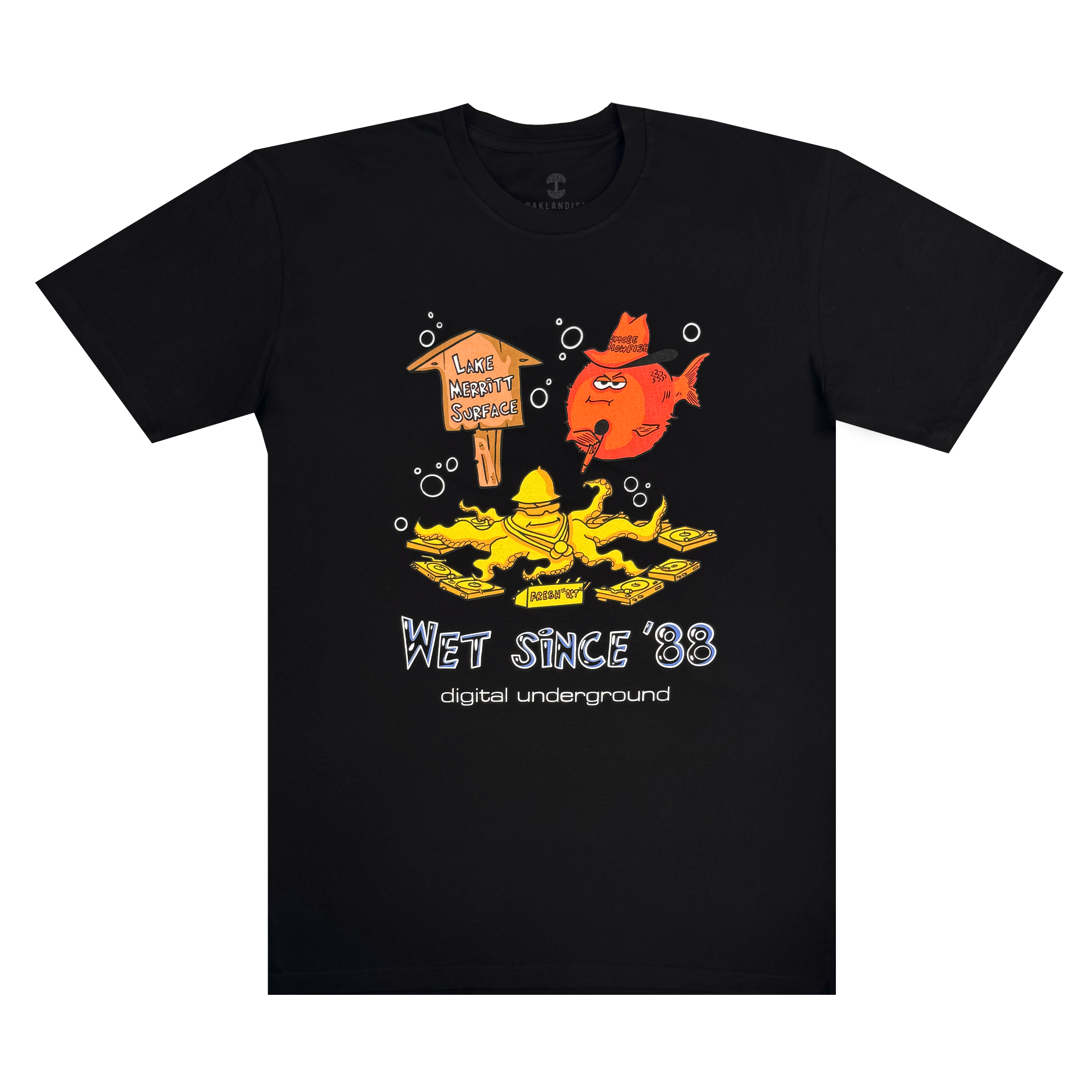 The Wet Since '88 Tee from Oaklandish features a cartoon yellow figure playing saxophone on a floating platform with "I Love Money So Much," accompanied by a red-hatted fish above. The design celebrates "Digital Underground" and Oakland roots, channeling the spirit of "Underwater Rimes.