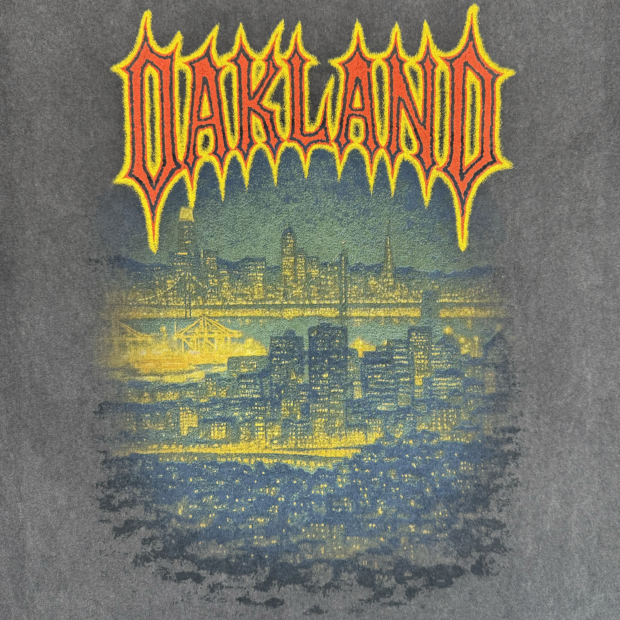 The Ember Tee by Oaklandish is a 100% cotton men’s t-shirt with a gritty, vintage look, showcasing the glowing Oakland skyline at night and "OAKLAND" in bold, jagged letters above the city. Classic fit and perfect for showing hometown pride.