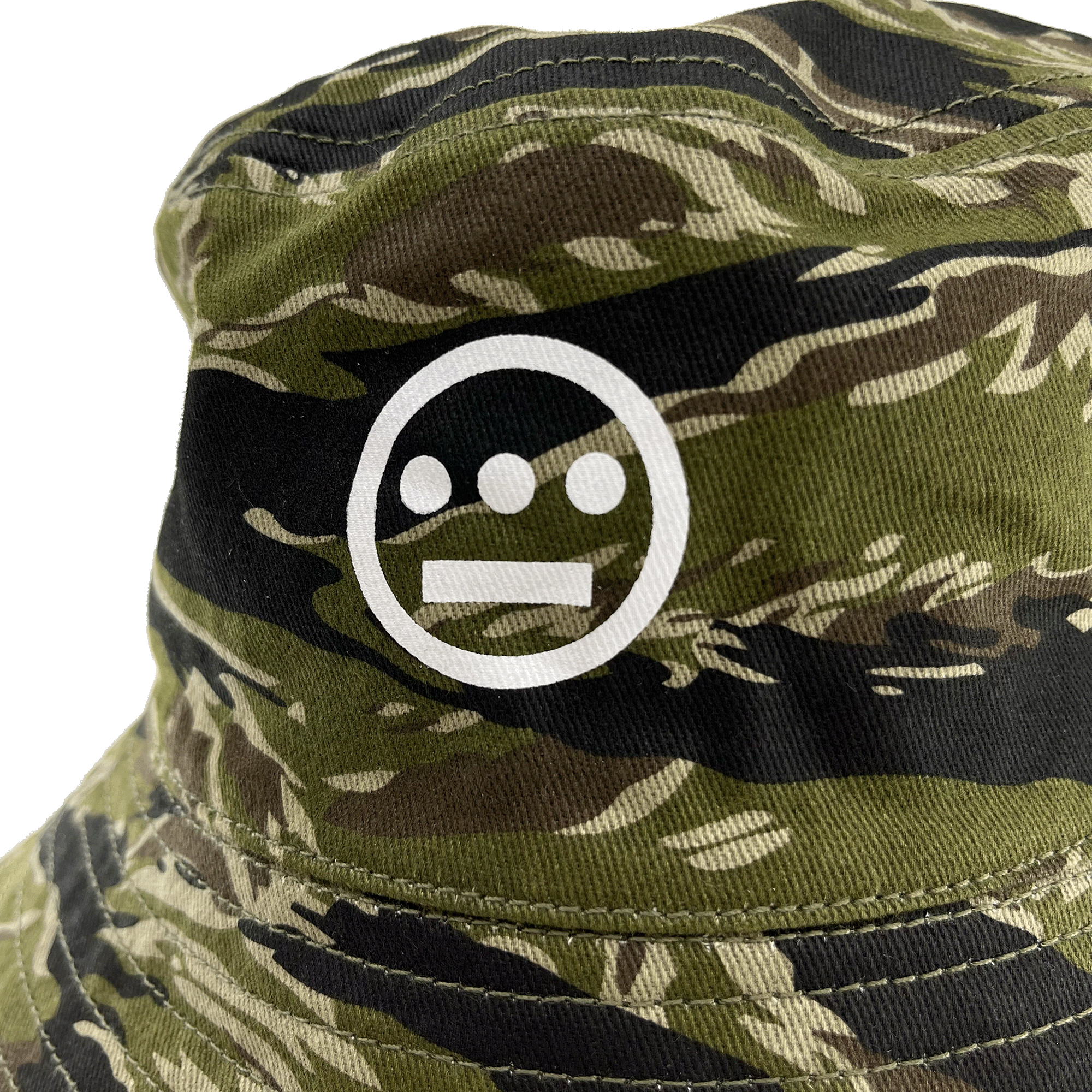 Close-up of white Hieroglyphics Hip Hop Crew logo on the front crown of a green camouflage bucket hat. 