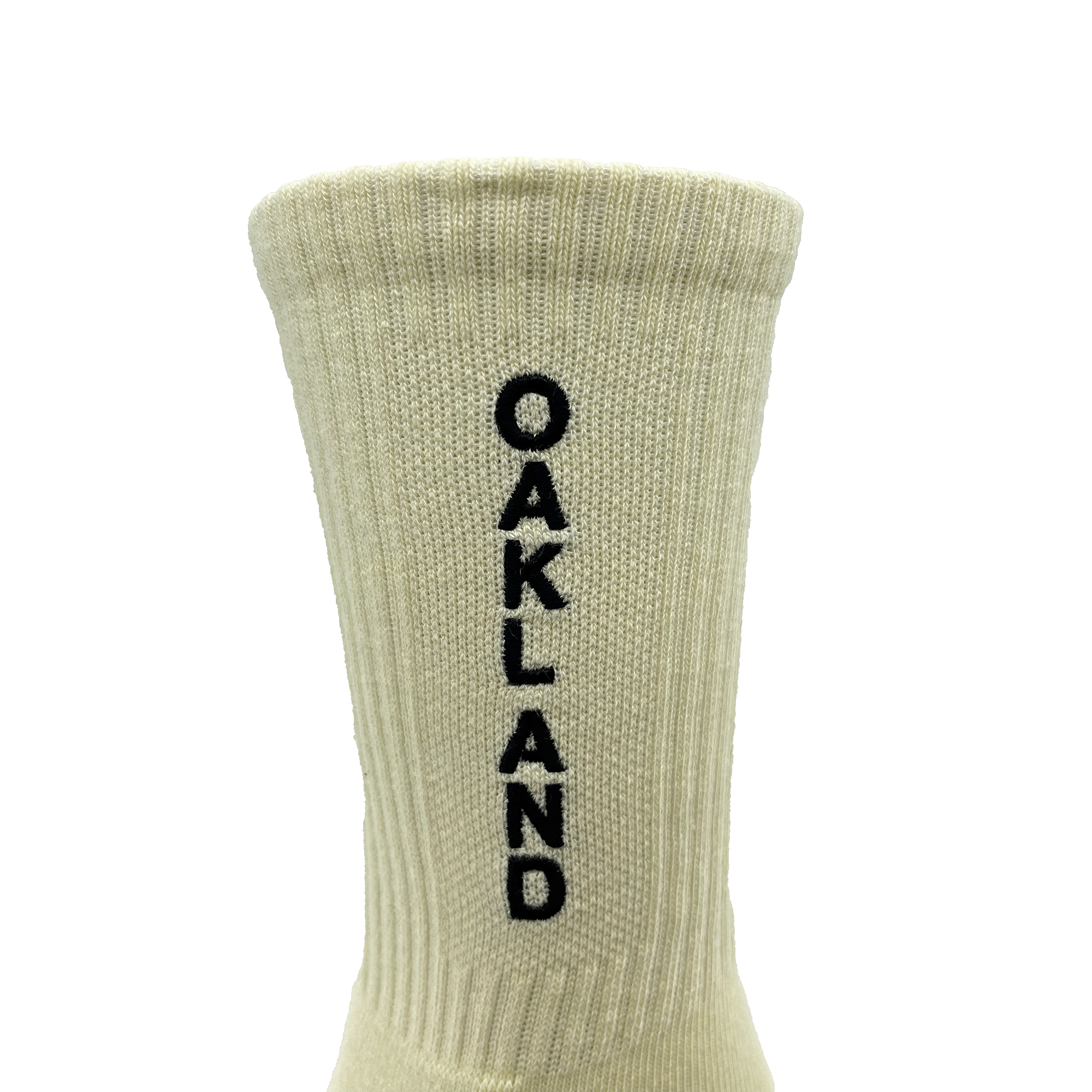 Close-up of embroidered black OAKLAND wordmark on the side of white crew sock.