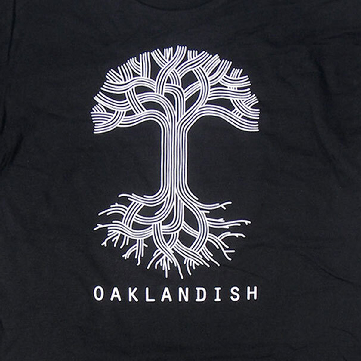 Close-up of large white Oaklandish tree logo and wordmark on the front chest of a black t-shirt.