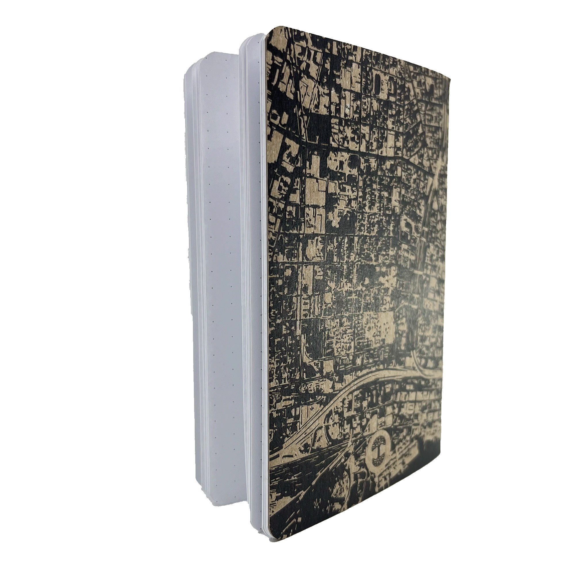 The Aerial Map Mini Notebook by Never Elsewhere is displayed standing upright with its pages slightly fanned out. This mini hardcover notebook boasts a stylish black and white city map design on the letterpress cover, rounded corners, and dot grid paper inside, offering an ideal layout for diverse writing needs.