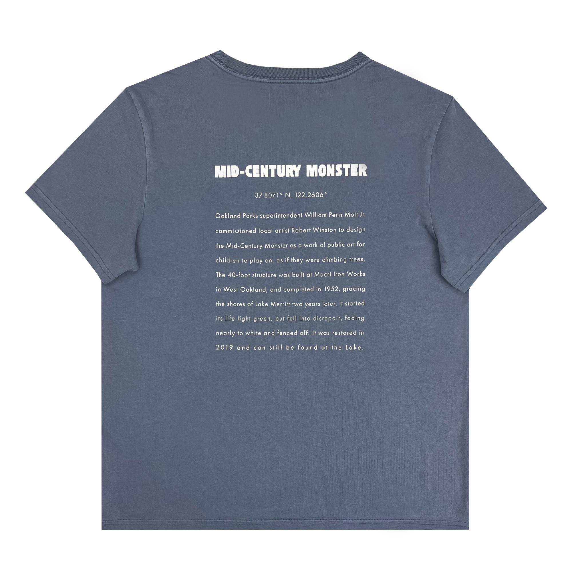 The Women's Mid-century Monster Tee from Oaklandish is a classic fit, 100% cotton gray t-shirt featuring white text on the back. The top reads "MID-CENTURY MONSTER," followed by coordinates "37.8071° N, 122.2606° W." Below that, a paragraph narrates about Oakland Park, sculptor Robert Winston, and a 40-foot structure restored in 2019 near a lake.