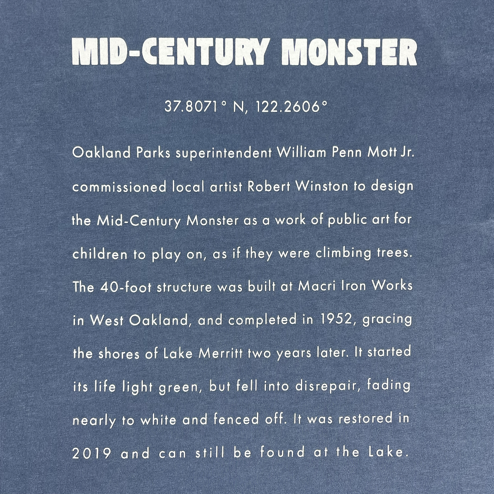 Text description of a sign titled "Mid-Century Monster" at coordinates 37.8071° N, 122.2606°. The sign explains that the Oakland Parks superintendent commissioned artist Robert Winston in 1952 to design the Mid-Century Monster play structure. This impressive 40-foot structure was restored in 2019 and is located near Lake Merritt, inspiring Oaklandish’s Women's Mid-century Monster Tee.