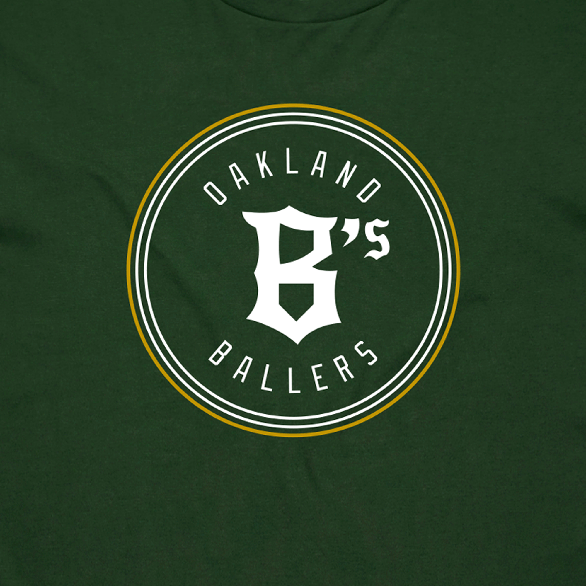 The Oakland Ballers Classic Tee from the Oakland Ballers brand is a dark green T-shirt featuring a white and yellow circular emblem in the center. Inside the circle, the text "OAKLAND BALLERS" appears at both the top and bottom, with a stylized "B's" in the center. The design celebrates Oakland’s new professional baseball team in the Pioneer League, giving it a sporty, team logo aesthetic.