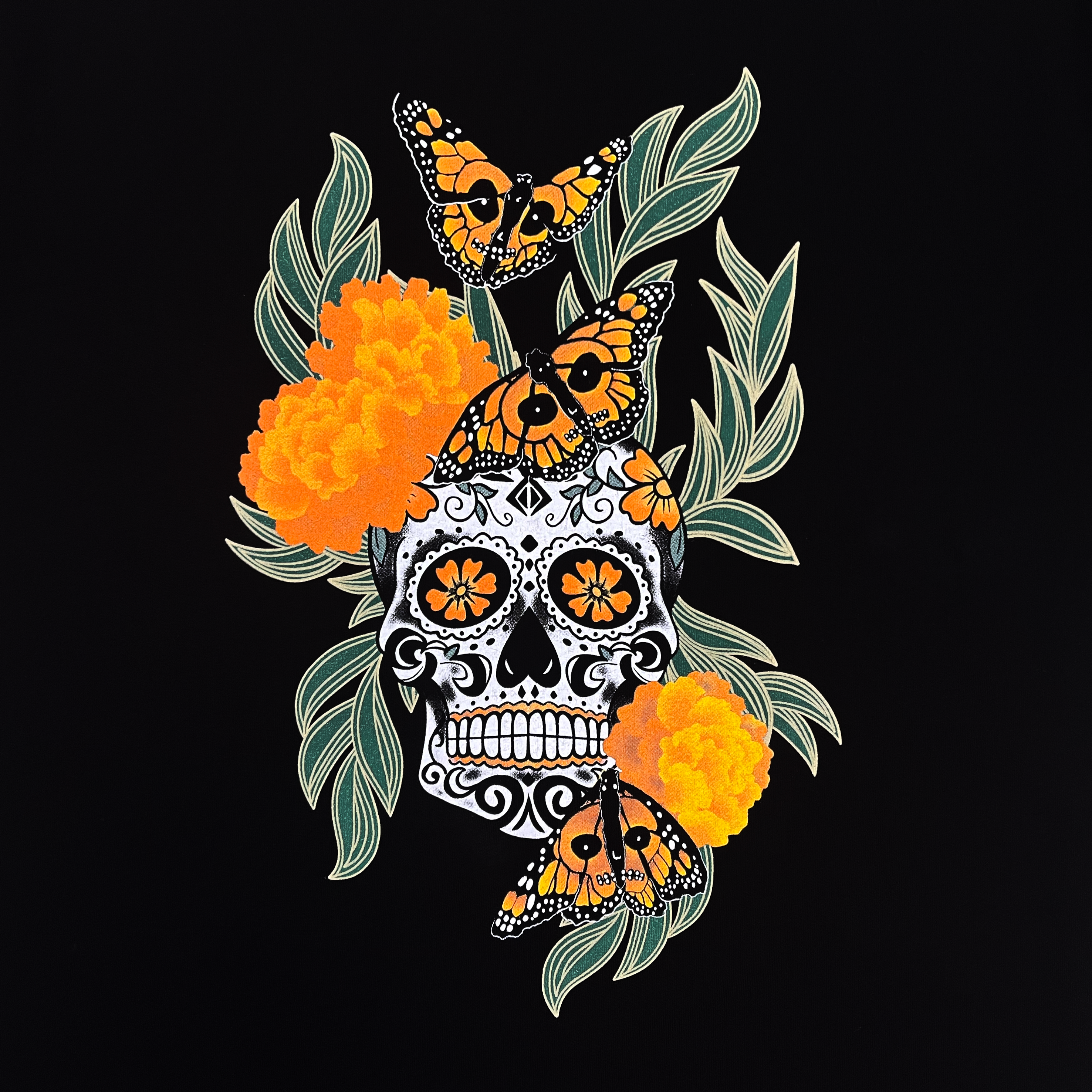 A close-up of Oakland artist Jet Martinez's graphic art depicts a sugar skull surrounded by Marigolds and Monarch butterflies on a black infant one-piece.