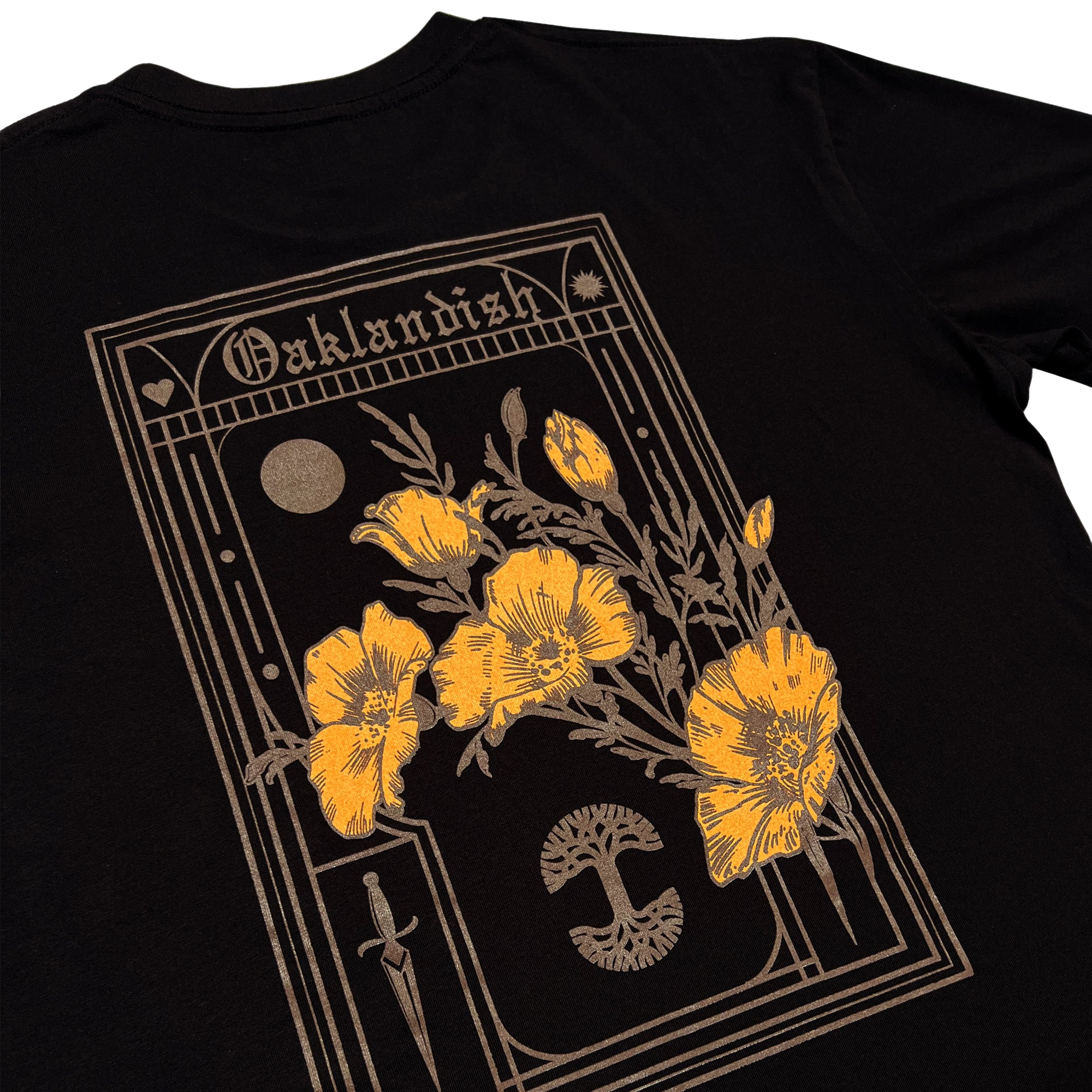 Oaklandish's Blossom Tee is a black men's cotton t-shirt with an intricate design. The design features a large rectangle at the top with the word "Oaklandish", a moon, a heart, and a dagger. Inside the rectangle are several yellow poppy flowers—the California state flower—displayed with detailed stems and leaves over a black mushroom graphic.