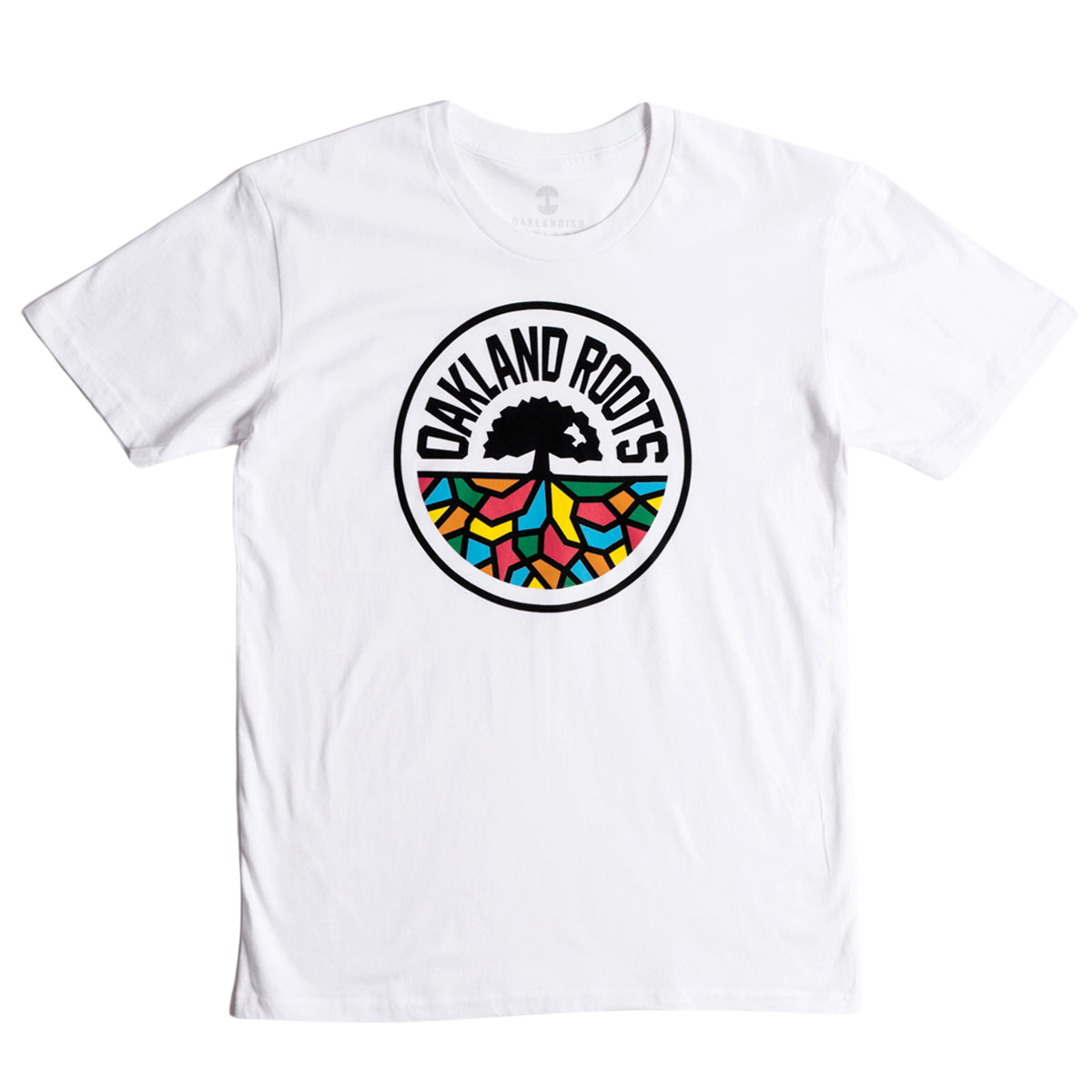 The Oakland Roots SC Classic Tee from Oakland Roots SC showcases a striking circular logo in the center. At its heart is a black tree with sprawling roots, accompanied by the text "Oakland Roots" elegantly arched above it. The roots branch out into vibrant sections of red, blue, green, and yellow, forming a stained-glass effect that symbolizes the club's commitment to social good.