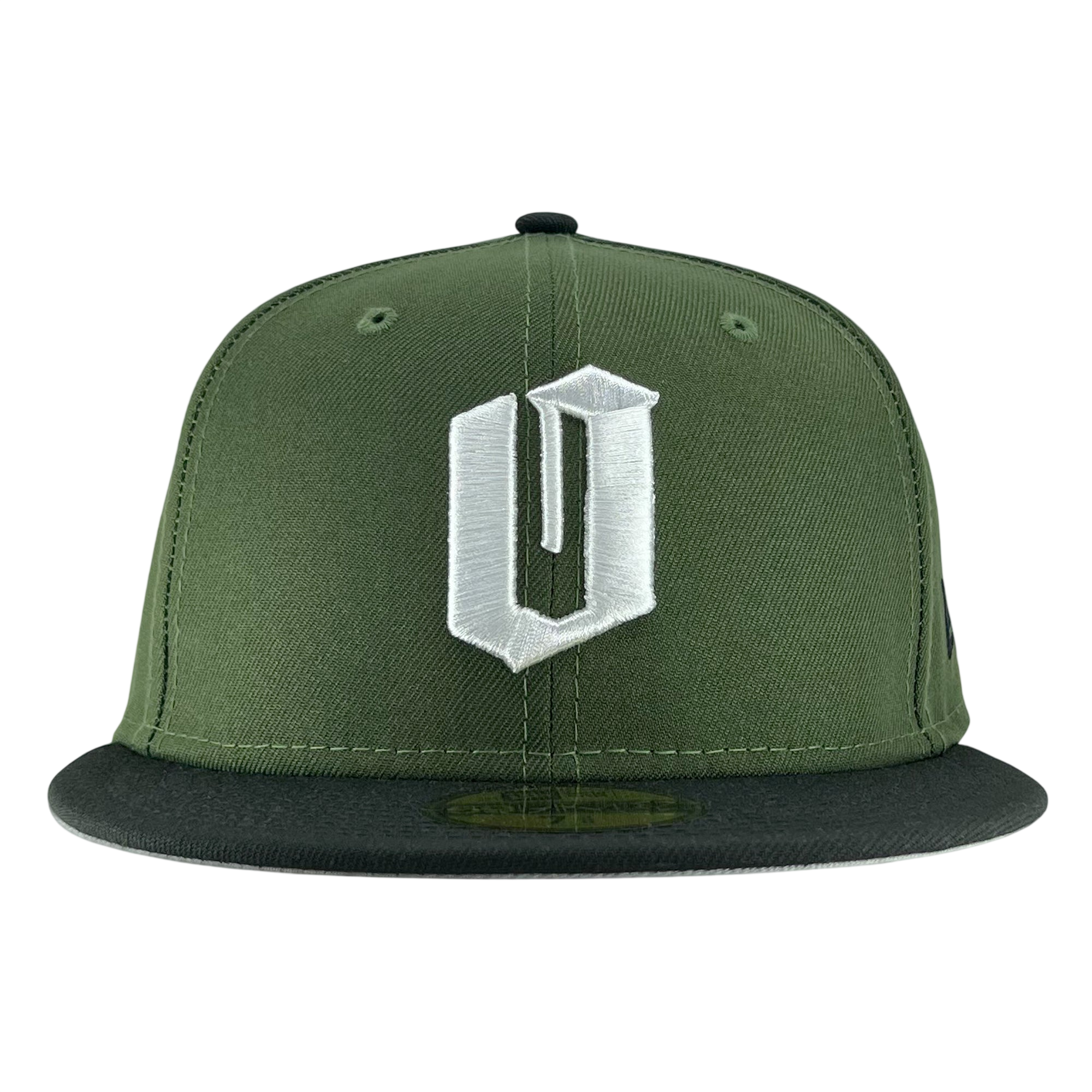 A New Era Official 59FIFTY Fitted Cap by Other, this green snapback features a bold, white embroidered “U” in a stylized font on the front panel and a black flat brim. Inspired by classic fitted cap design, it adds an Oaklandish edge to your style. The plain white background emphasizes the cap’s color and distinctive details.
