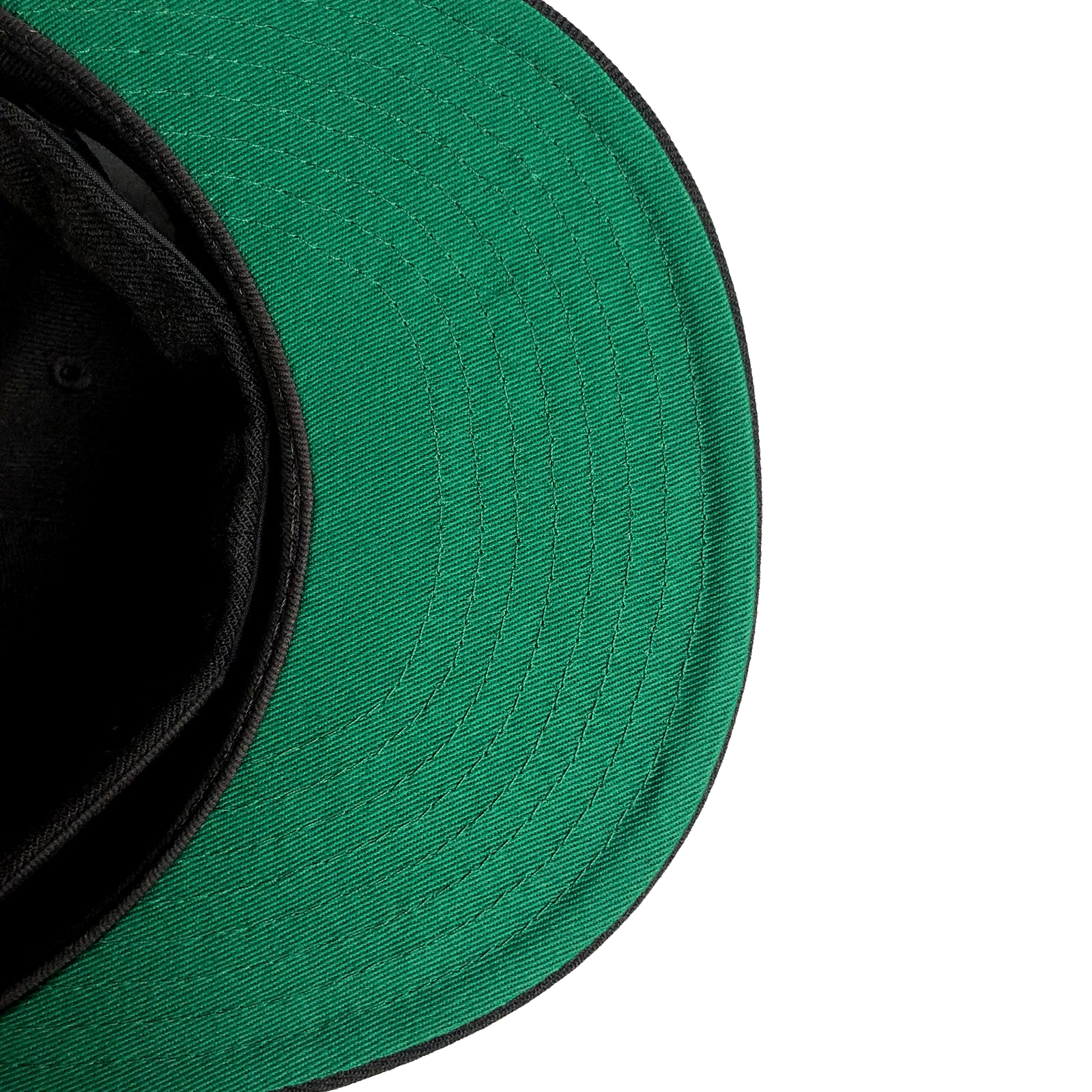 A close-up of a New Era Oakland Roots SC 59FIFTY Fitted Cap with a black underside. The image captures the cap lying on its side, revealing the green fabric of the visor and part of the black interior. The texture and stitching are clearly visible, indicating its affiliation with Oakland Roots SC against a clean, white background.
