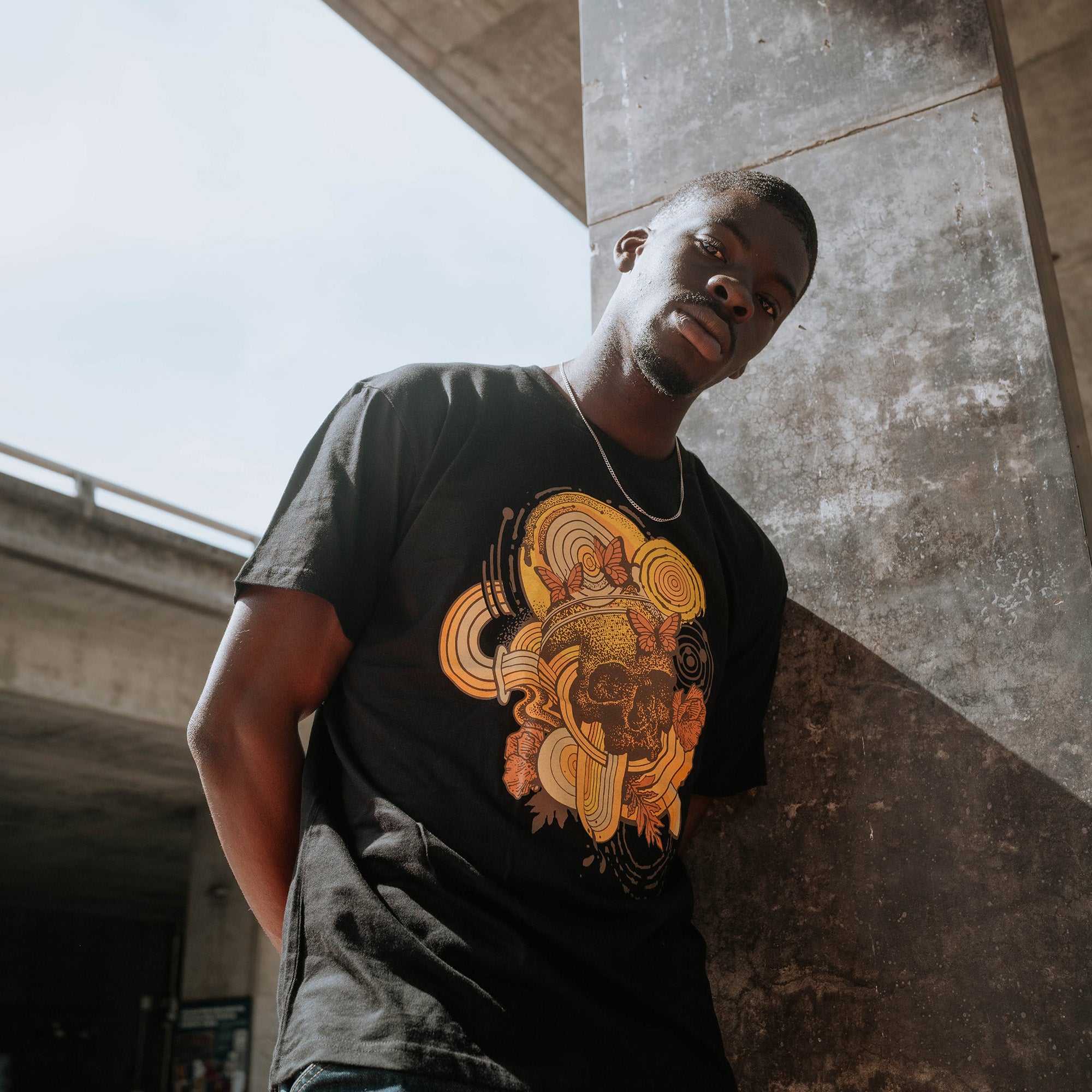 Male outside wearing Oaklandish rebirth black t-shirt.