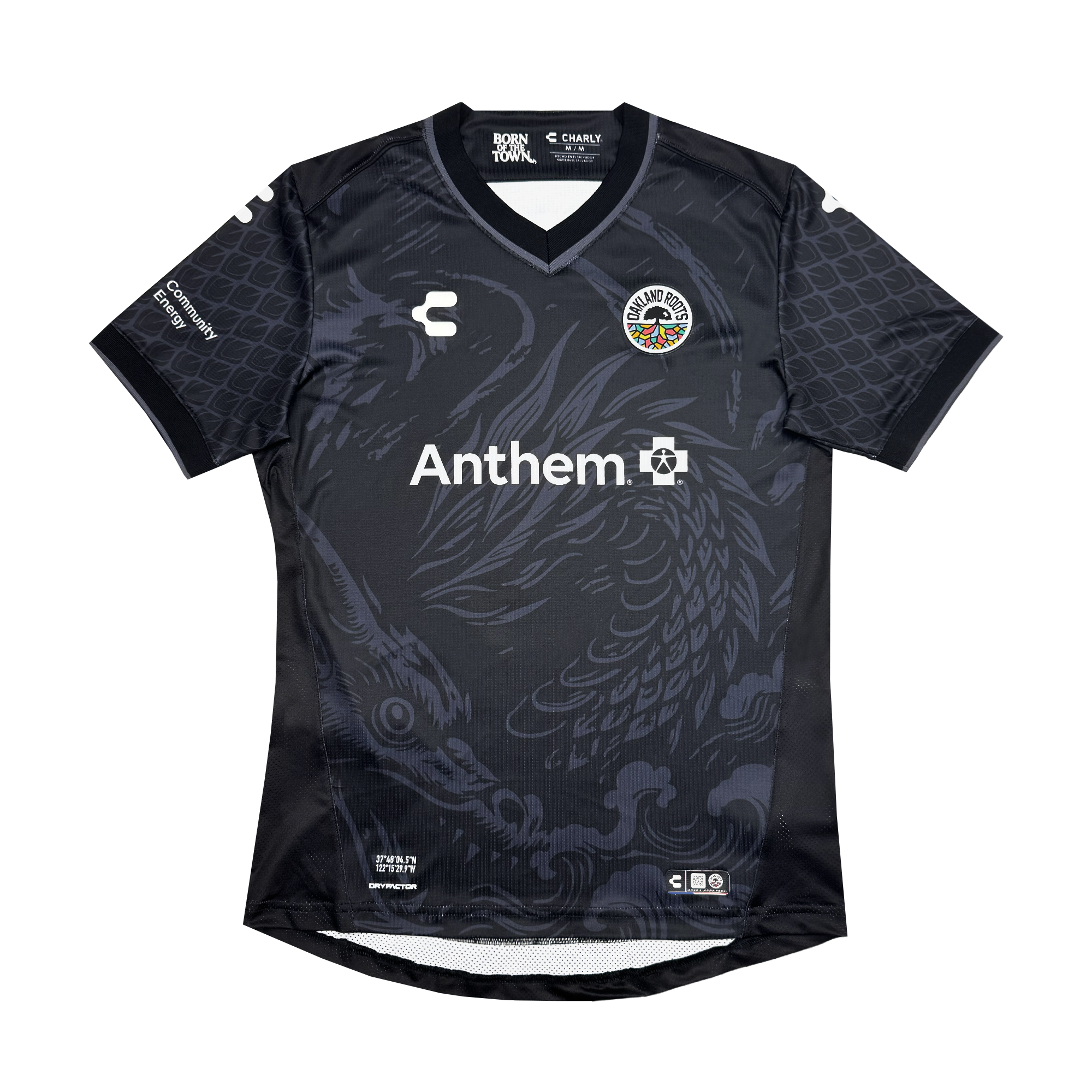The Unisex Oak-ness Awakens Kit by Oakland Roots SC is a black soccer jersey featuring dark gray serpent-like dragon graphics inspired by Oakland folklore, with the club crest left, white "Anthem" sponsor center, and manufacturer's logo right.