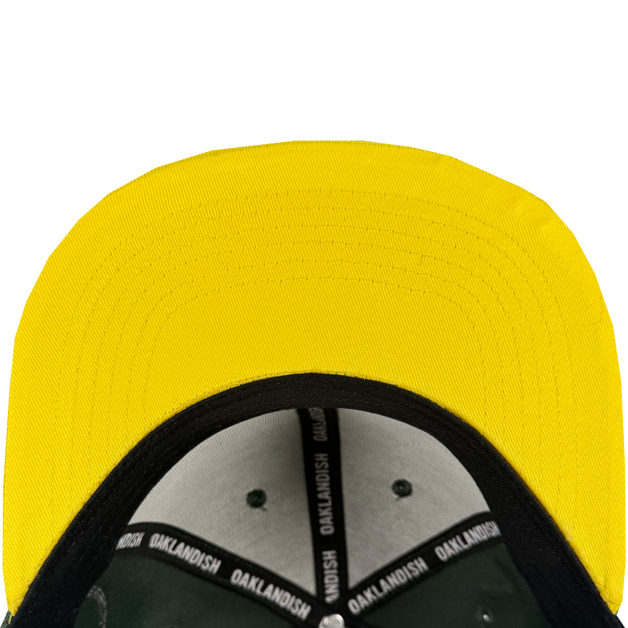 Close-up of the underside of the Oakland Roots SC Arch Text Snapback's yellow brim. Black sweatband strips with white "OAKLANDISH" text line the inside; visor underside is black. Plain white background highlights Oakland Roots SC branding.