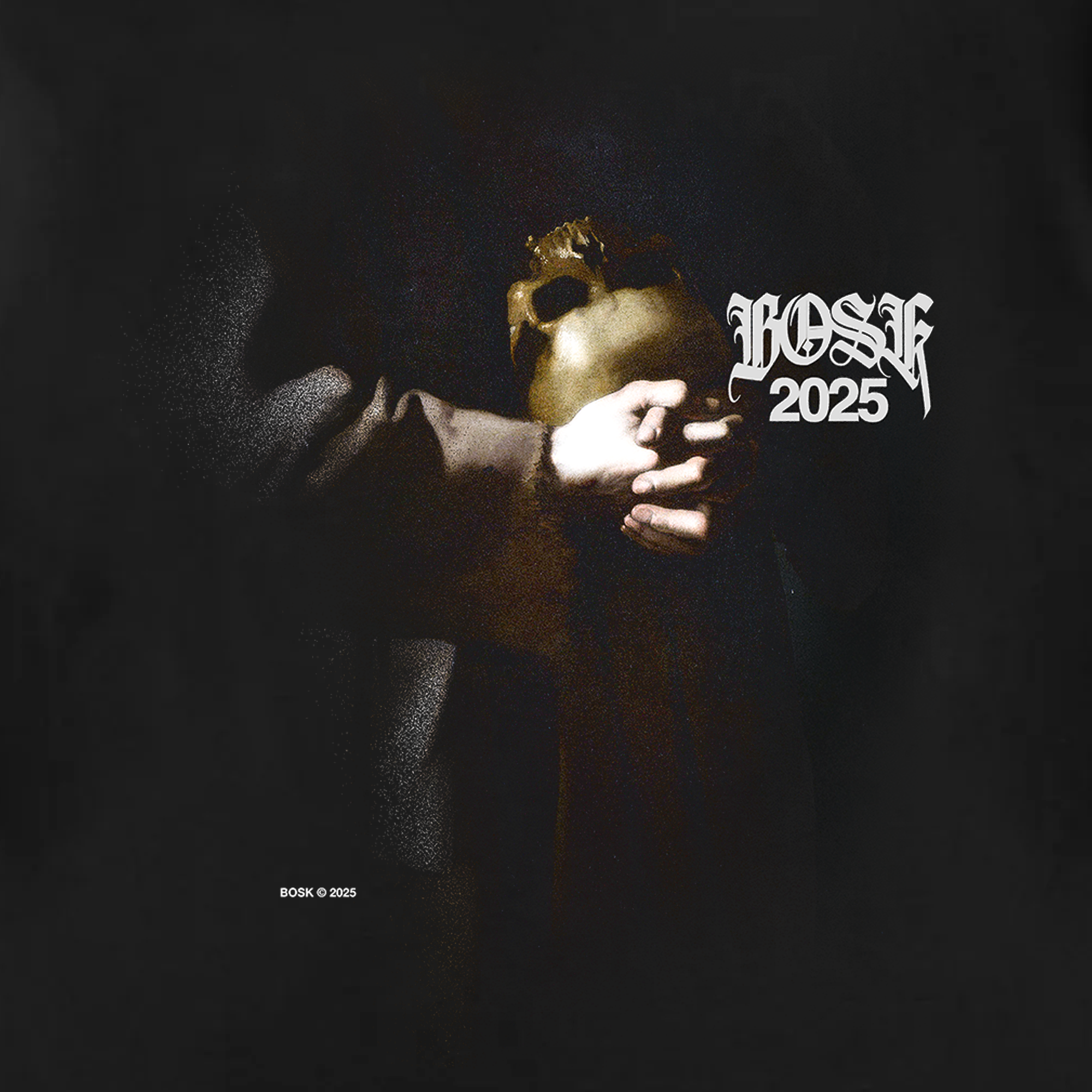 A dimly lit image of a figure in brown robes holding a gold mask is illuminated against black, with stylized white "BOSK 2025" text above—ideal artwork for the BOSK St. Francis Tee, crafted in heavy-weight cotton.