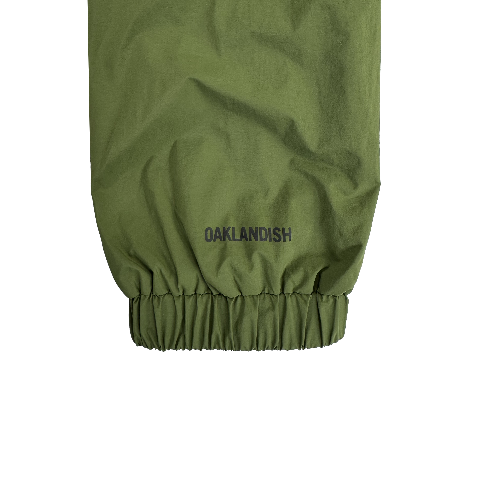 Close-up of the Susurrus Track Top by Oaklandish in olive green, showing the men's classic fit sleeve with an elastic cuff. "OAKLANDISH" is printed in black above the cuff, standing out against a plain white background.