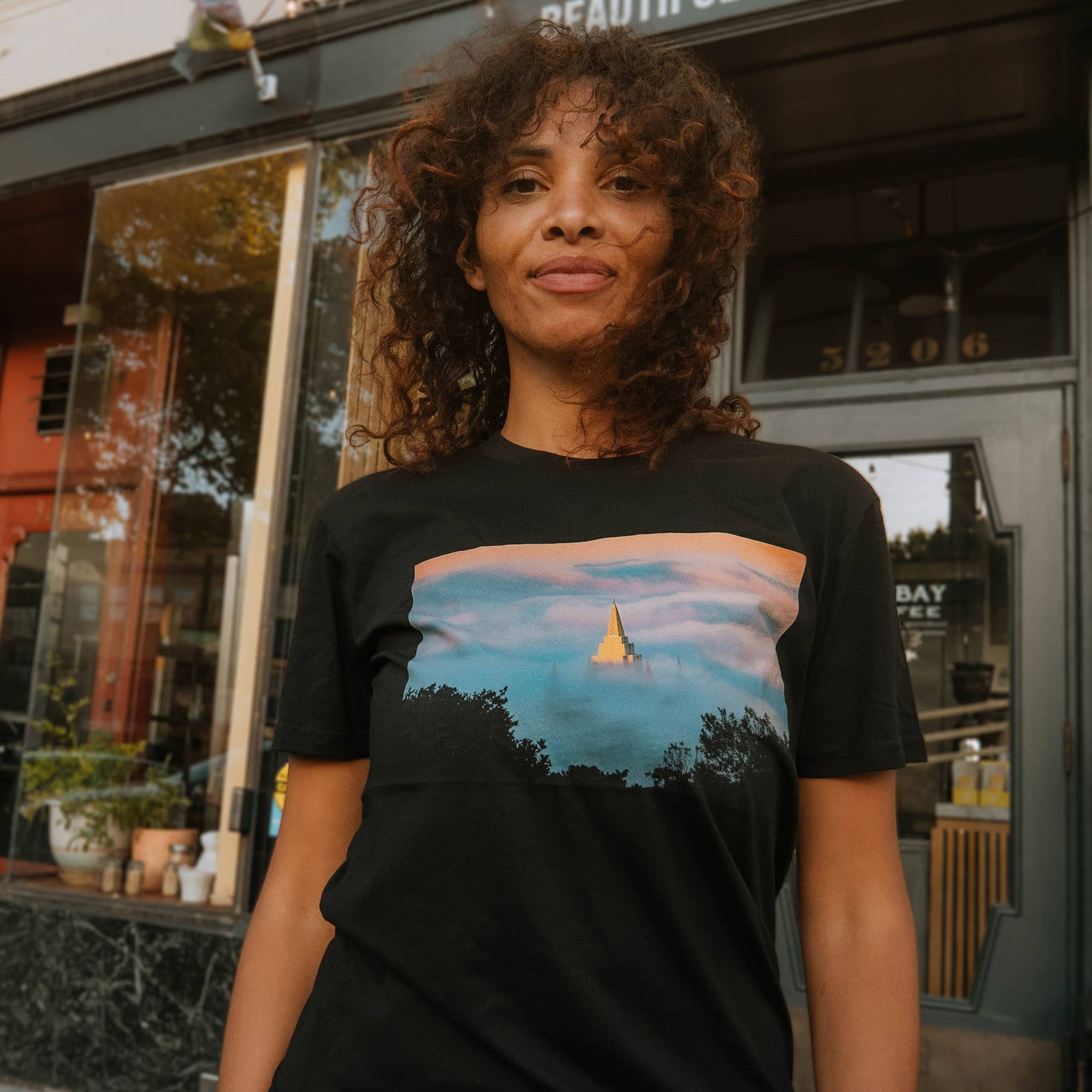 Woman wearing Oaklandish Temple Swirl black t-shirt.