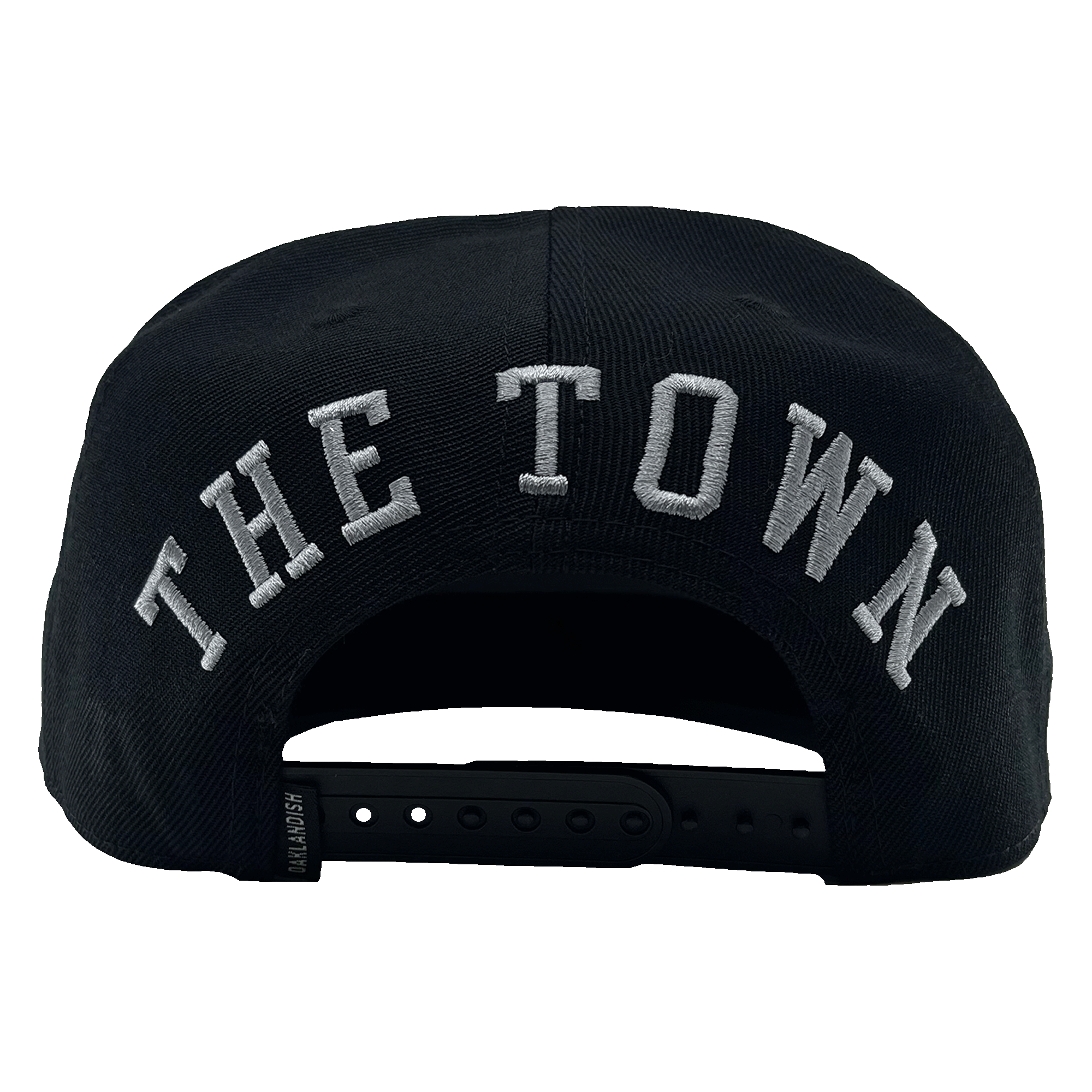 The rear view of "The Town Aft Snapback" by Oaklandish features "THE TOWN" prominently embroidered in large white letters. The hat's adjustable snapback closure, a small label tag on the side, and an embroidered Oaklandish tree logo are also visible.