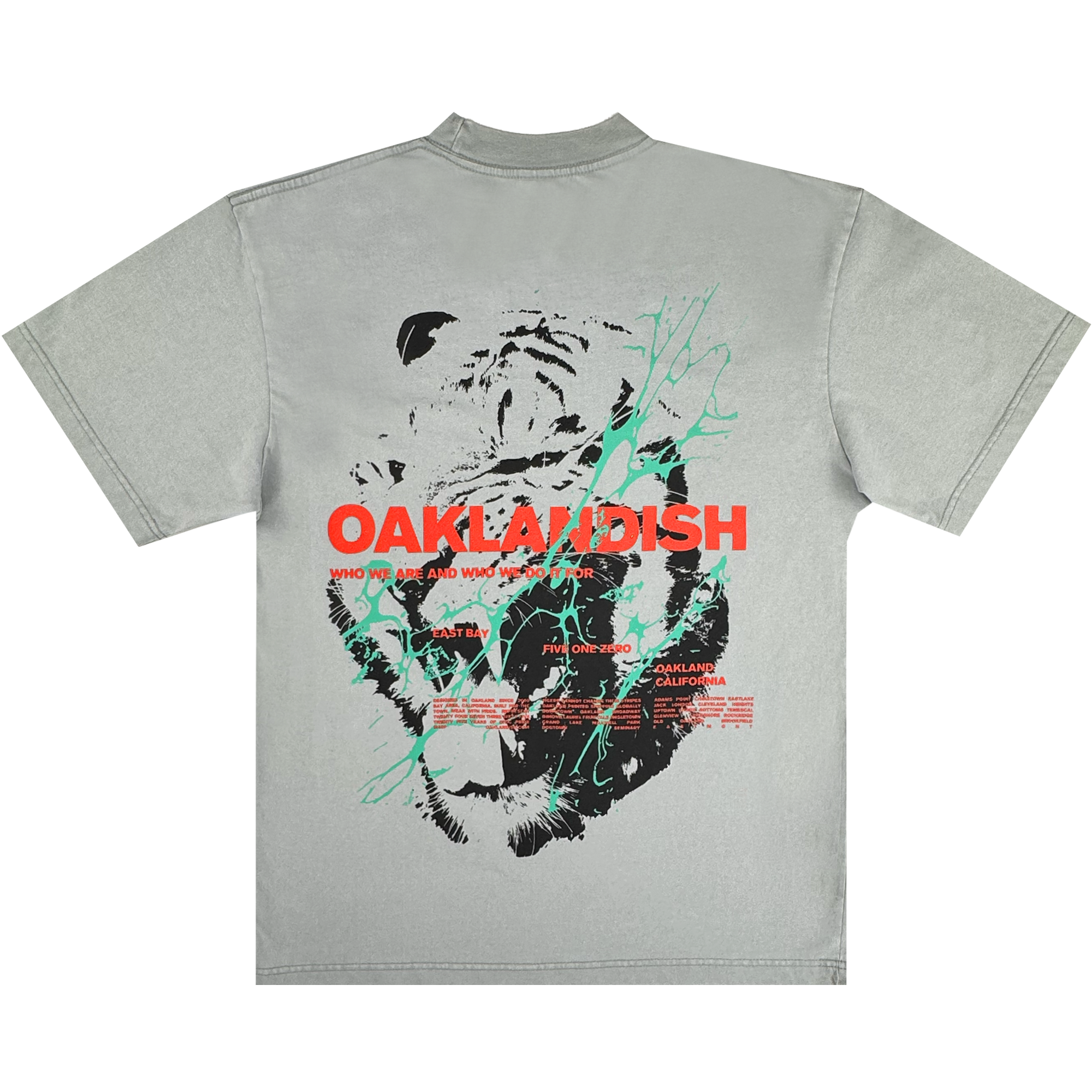 The Tiger Blood Tee by Oaklandish is a vintage grey heavyweight cotton shirt featuring a bold black and white tiger face graphic on the back, with striking red "OAKLANDISH" text, white and red details, and green accent lines.