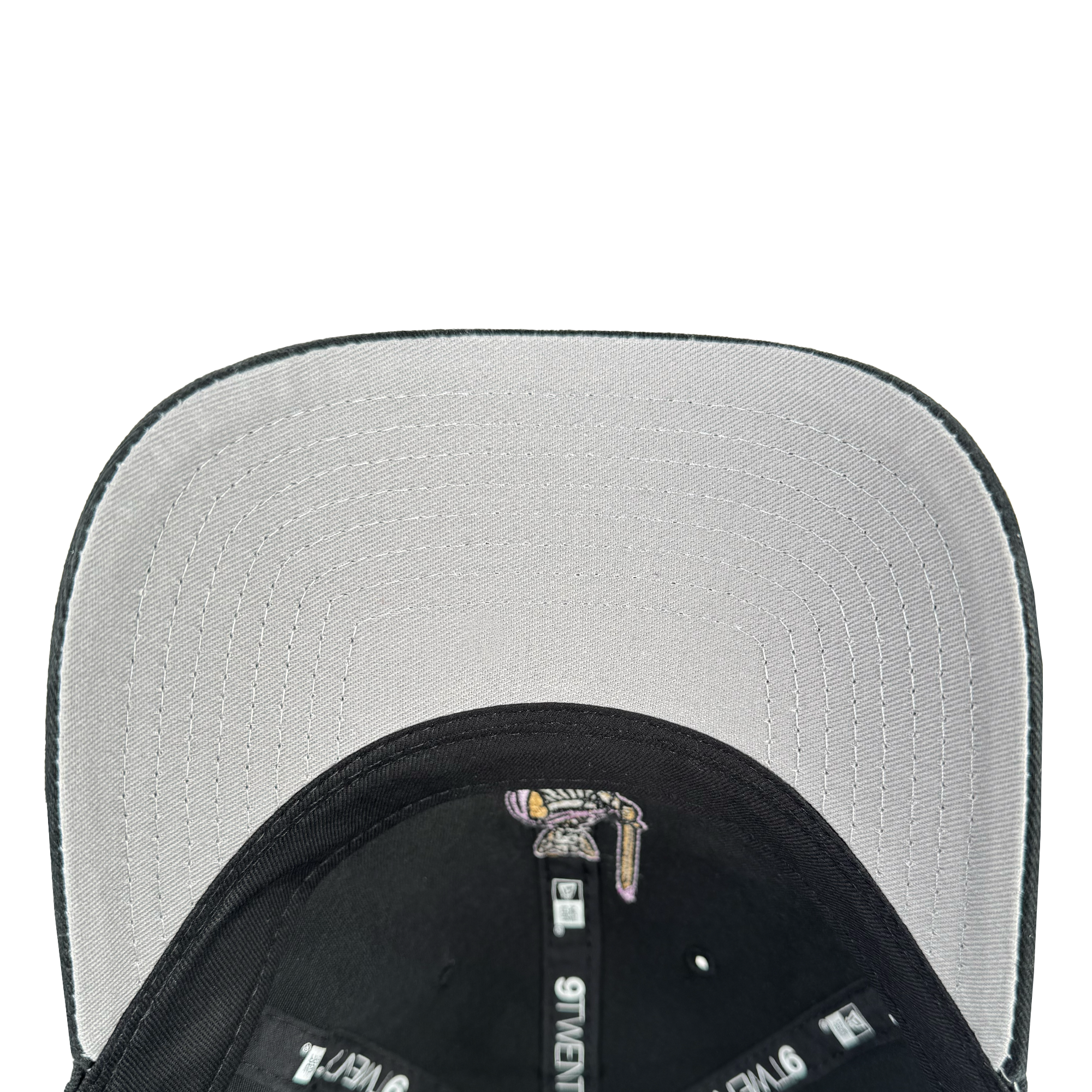 Close-up of the GSV 9TWENTY Dad hat by GSV, featuring a light gray brim. Concentric stitching, branded tags, a small logo, and an adjustable strap are visible on the interior headband.