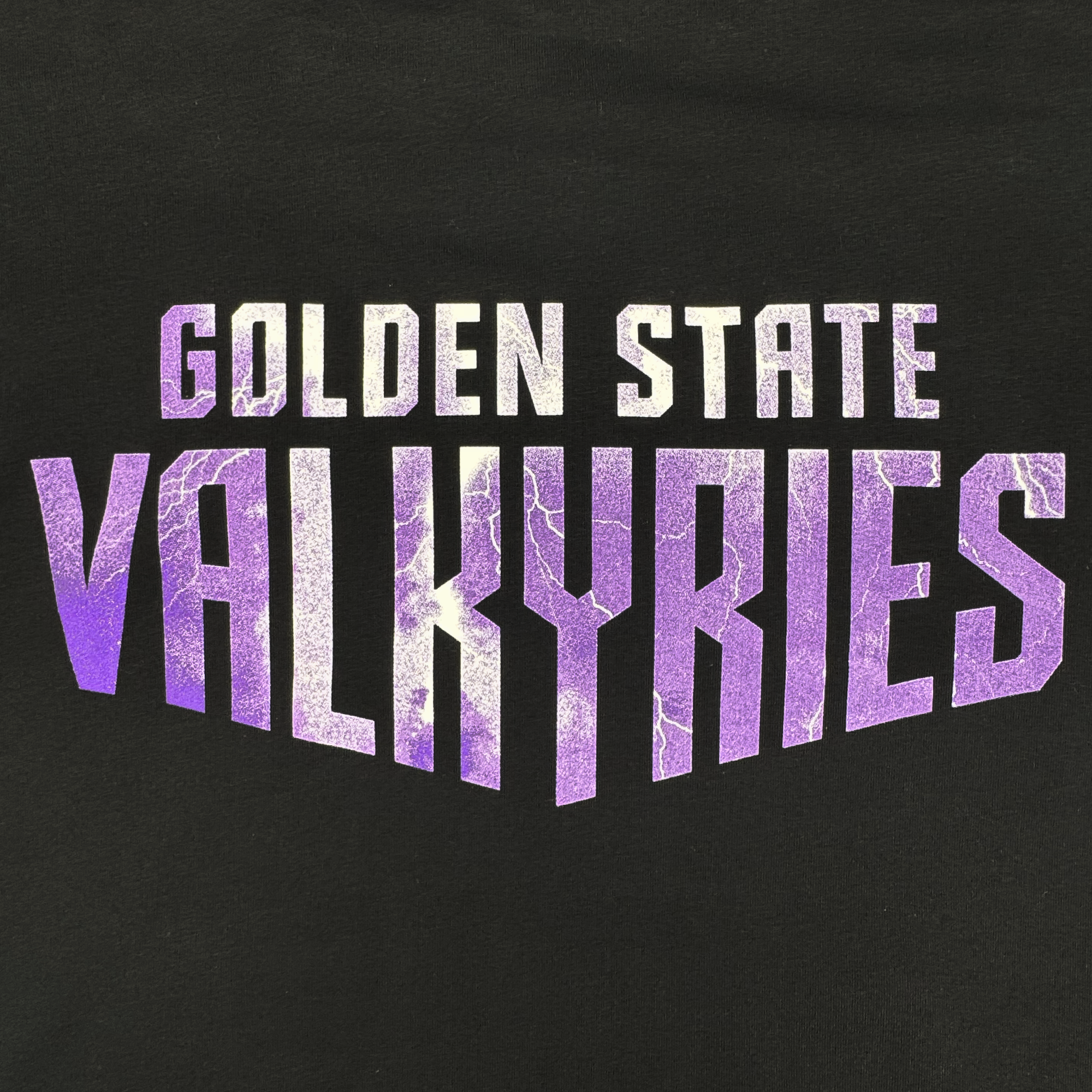 The GSV Women's Golden State Valkyries Violet Lightning Hoodie features a black background with bold white and purple “GOLDEN STATE VALKYRIES” text. The large "VALKYRIES" has a purple gradient lightning effect, perfect for Valkyries fans.